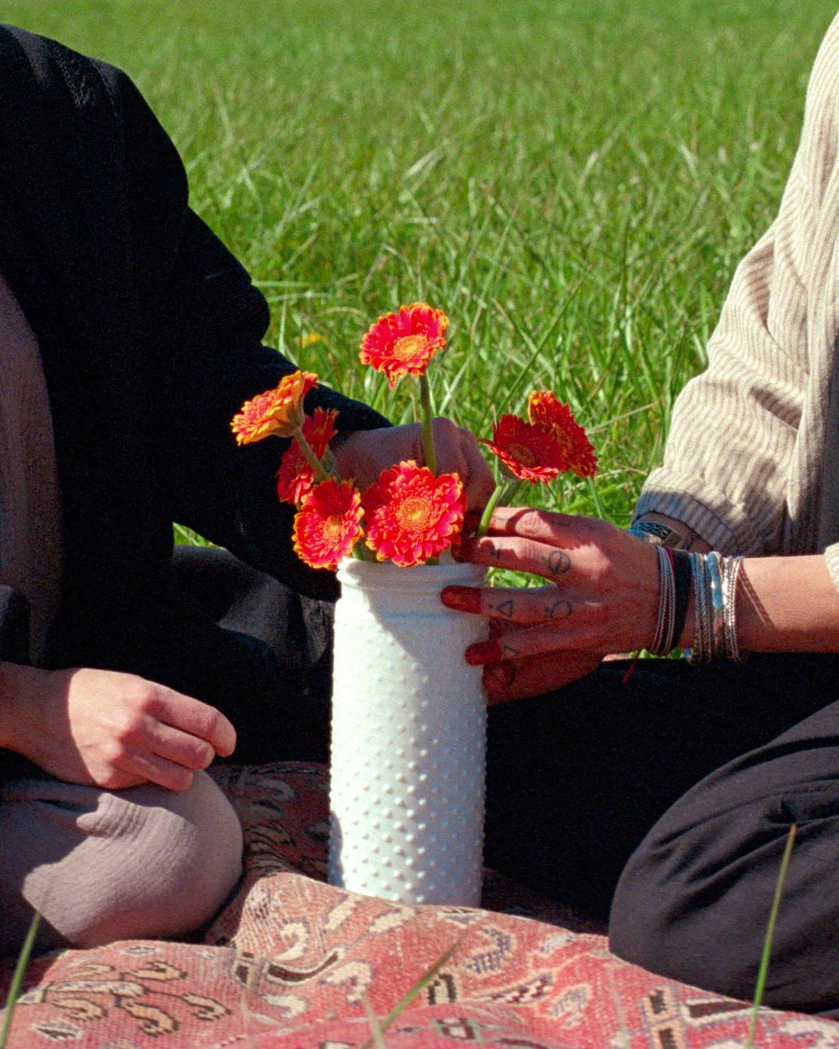 Workshop participants sharing farm-grown flowers during a nature-based activity centered on care and connection.