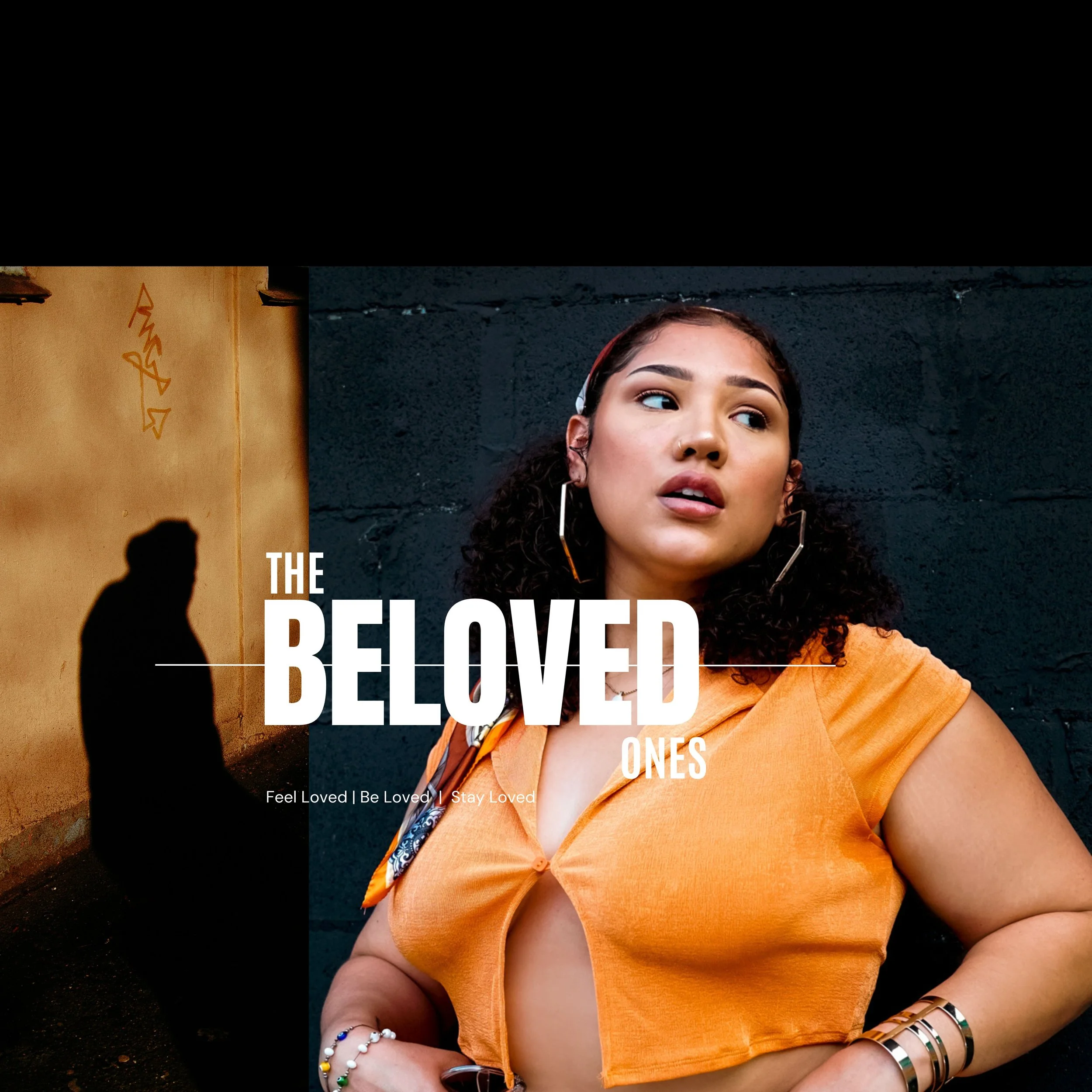 A woman with dark, curly hair and earrings, wearing an orange top and jewelry, stands outdoors against a dark background with a yellow wall and graffiti.
