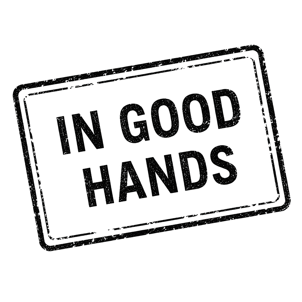A black and white image of a rectangular sign with the text "IN GOOD HANDS" inside it.
