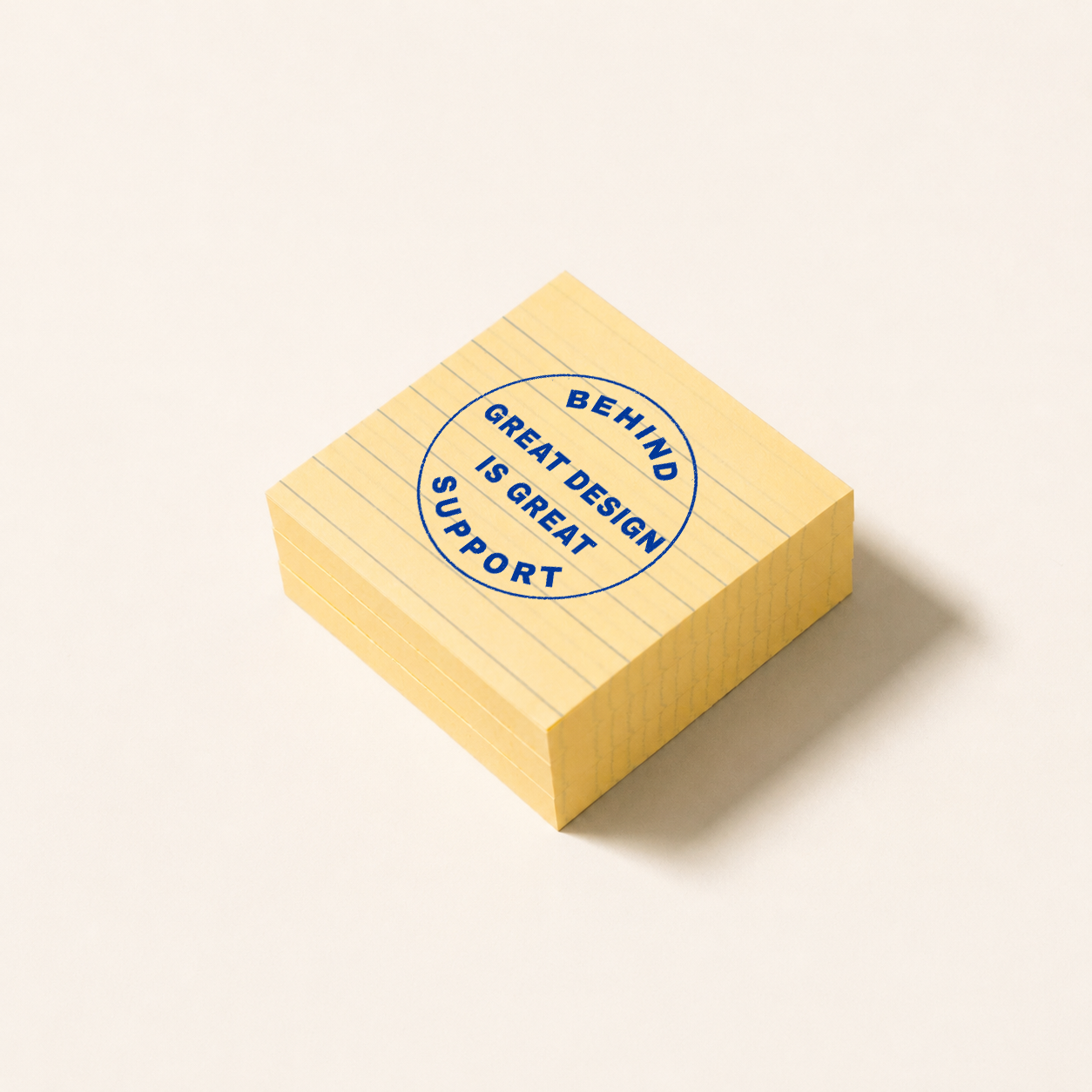 Stack of yellow sticky notes with a blue circular stamp that reads, "BEHIND GREAT DESIGN IS GREAT SUPPORT", placed on a white surface.