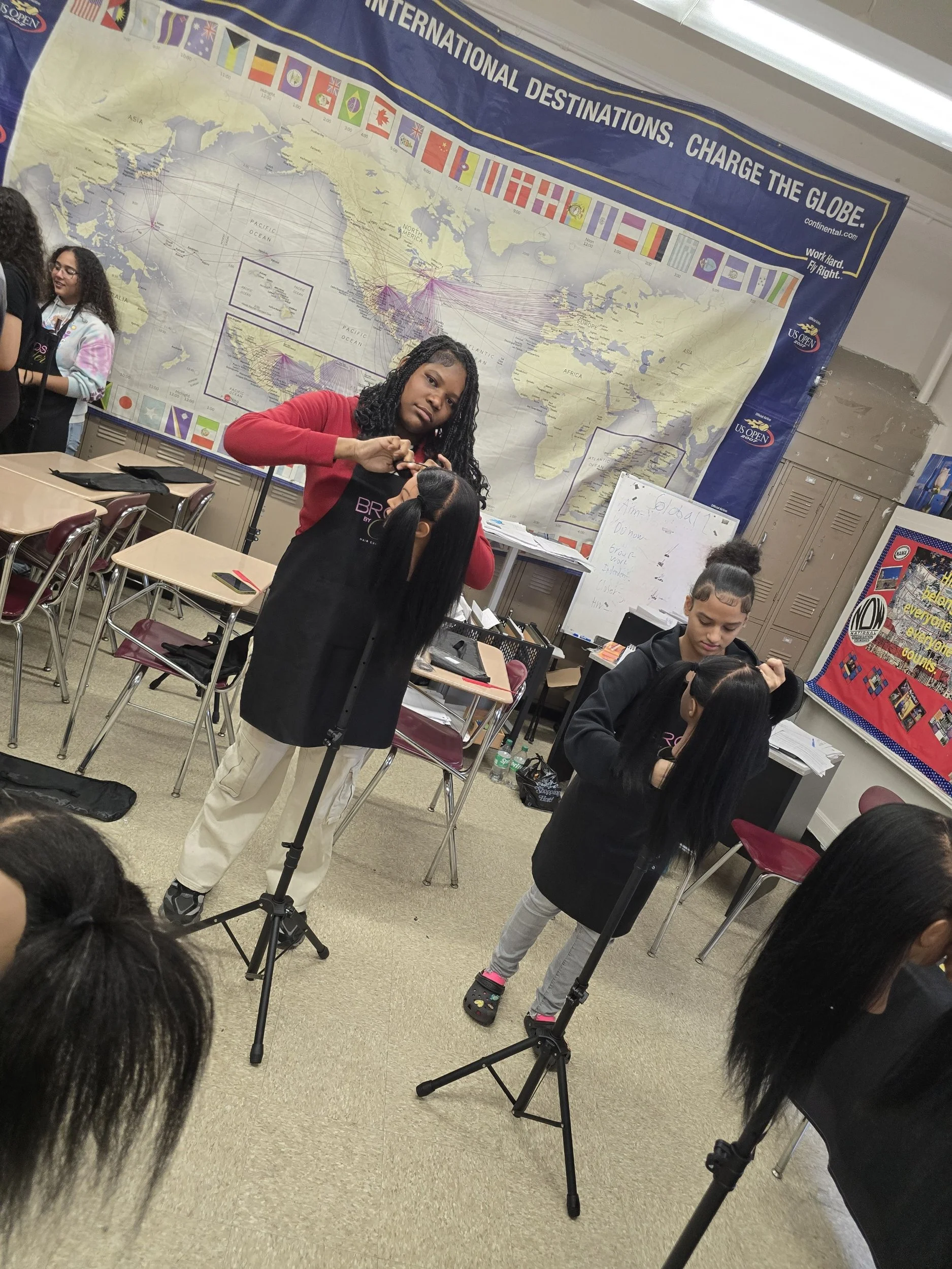 Students in a classroom with a world map and a poster about international destinations. Students are working or preparing for an activity.