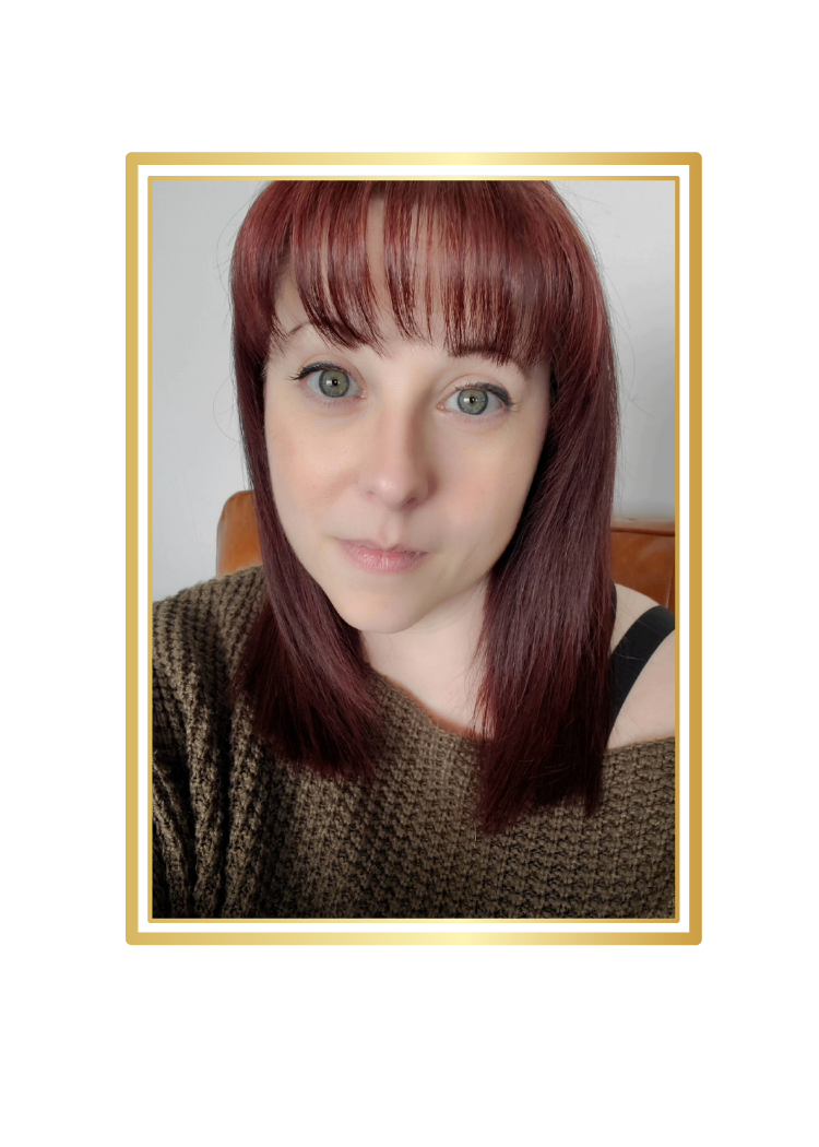 A woman with shoulder-length red hair, green eyes, and light skin, wearing a brown knitted sweater and black top, posing for a selfie against a plain background.