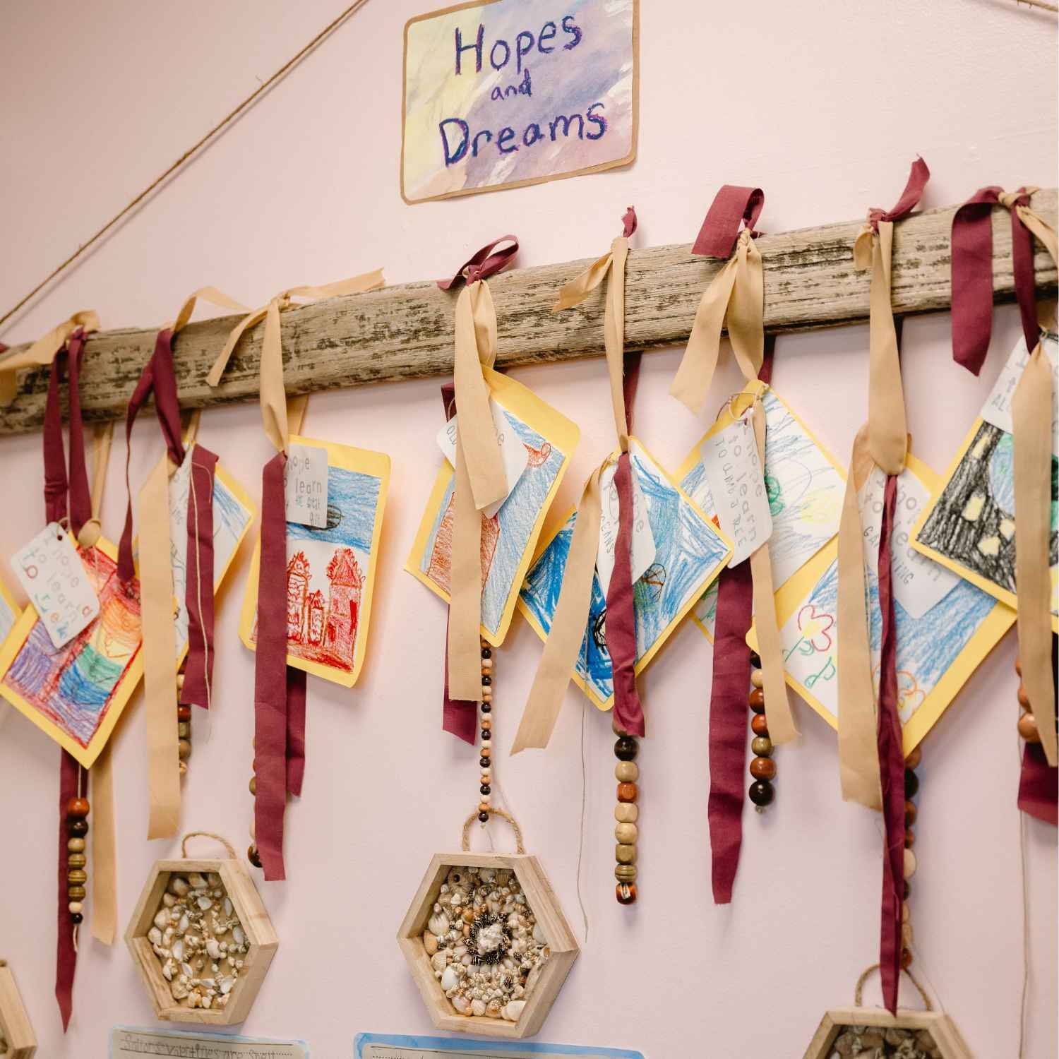 A “Hopes and Dreams” display at Nantucket Lighthouse School’s Project Night showcases student artwork and handmade necklaces crafted from beads and shells, celebrating creativity and personal expression.