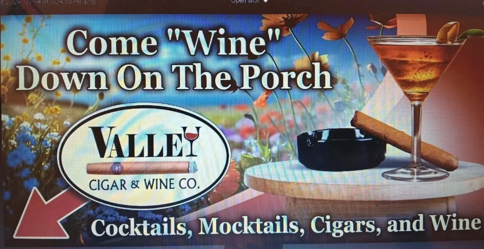 Advertisement for Valle Cigar & Wine Co. inviting people to come down on the porch for cocktails, mocktails, cigars, and wine. The ad features a martini glass with a cigar resting on its base, a cigar on a table, an ashtray, and a background of colorful flowers.