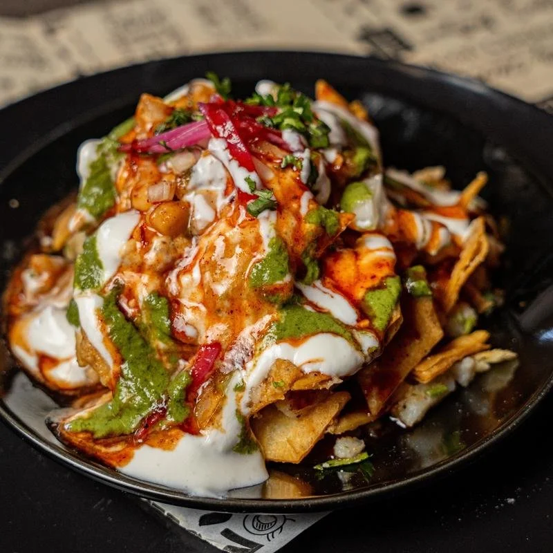 Crispy fried dough wafers (papris) mixed with boiled potatoes, and onions, and is topped with yogurt and spicy and tangy chutney made with tamarind and mint. | Vegetarian