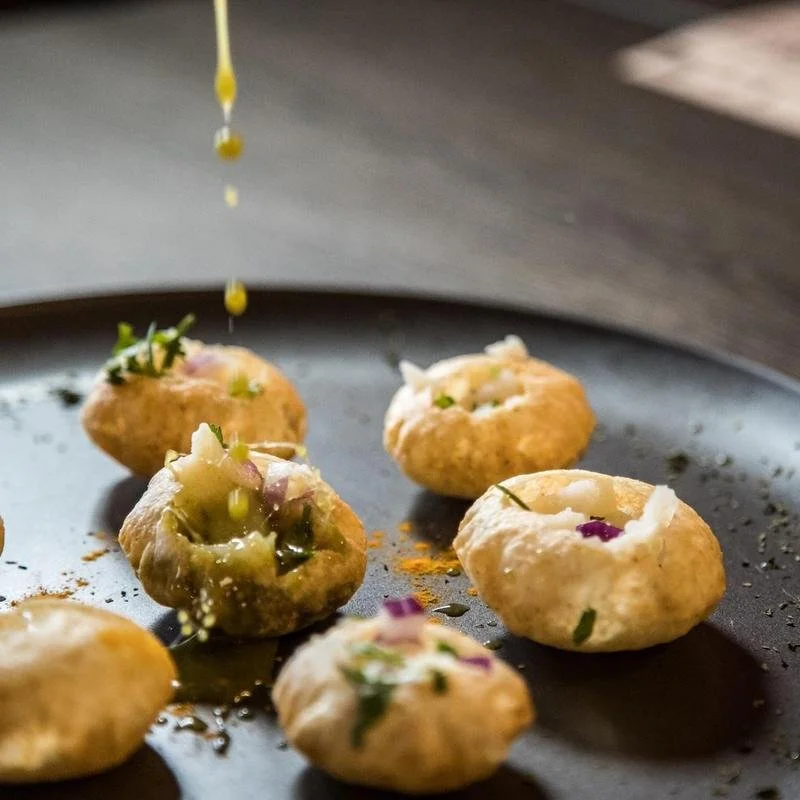 Also known as, Panipuri. Crispy puff, filled mashed potatoes and chickpeas, infused with minty herbal water. | Vegetarian
