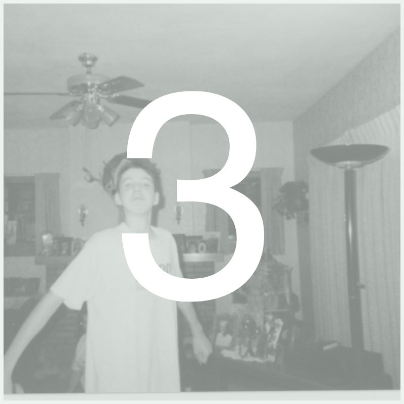 A girl in a room with a ceiling fan, lamp, and vertical blinds, standing with arms outstretched and a large number 3 overlayed on the image.