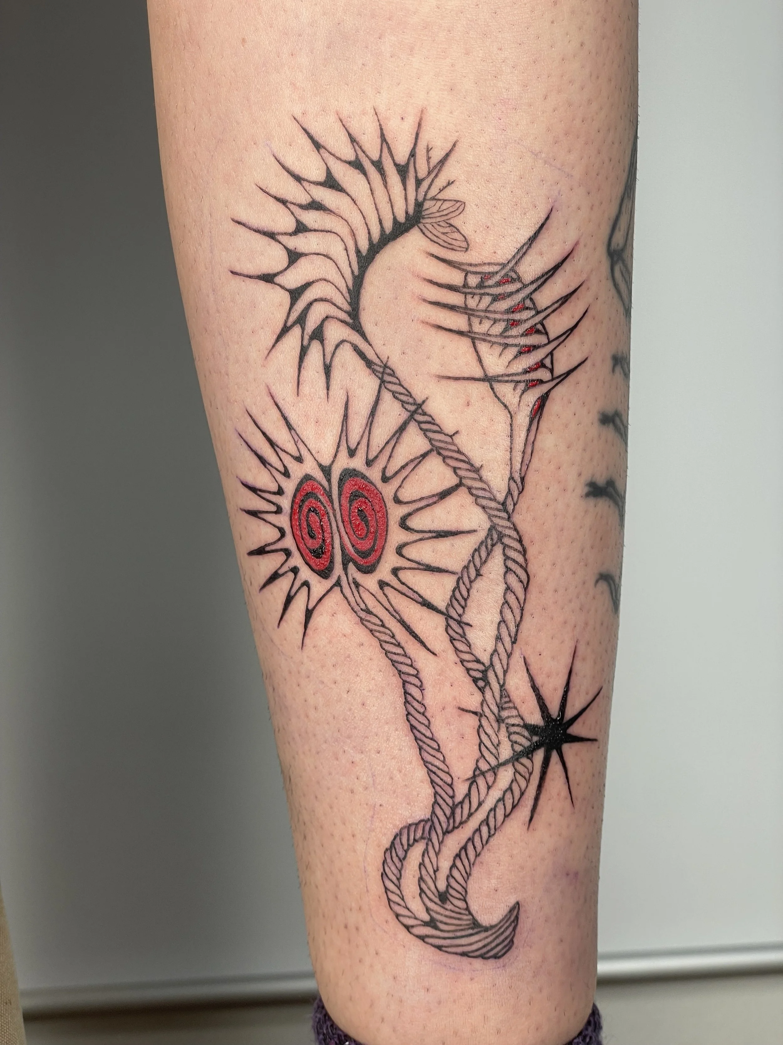 Tattoo of a venus fly trap made of abstract, spiky lines and ropes, with a small star at the bottom.