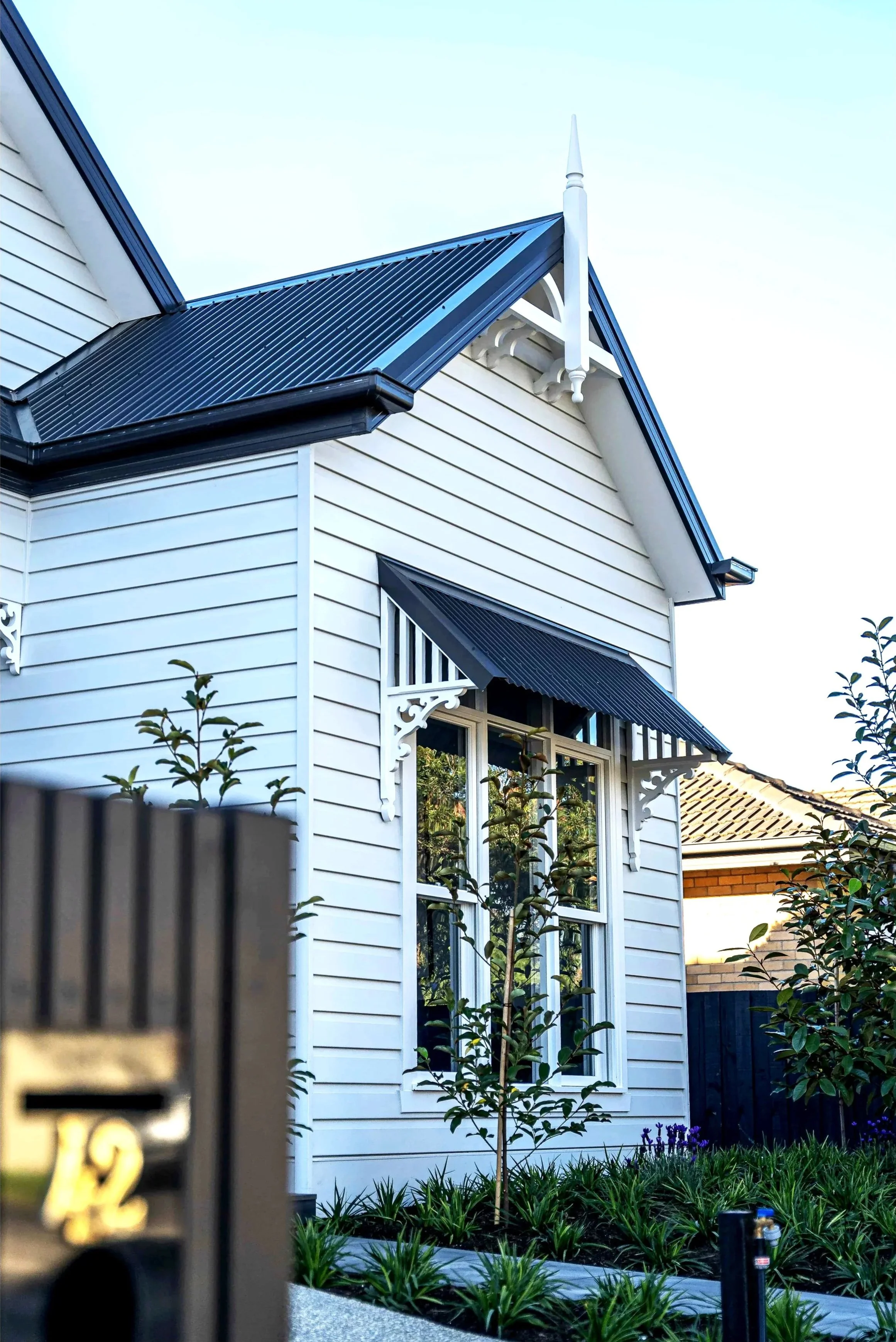 A traditional Hamptons style home with a feature window awning.