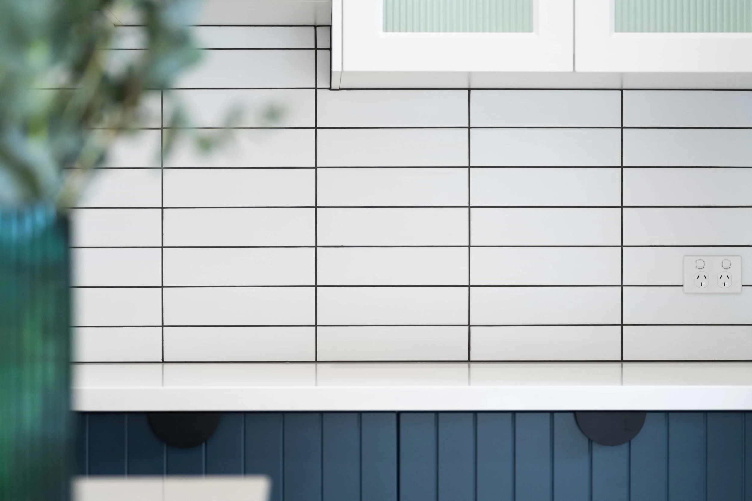 Close-up of a white subway tile splashback in a stacked pattern.