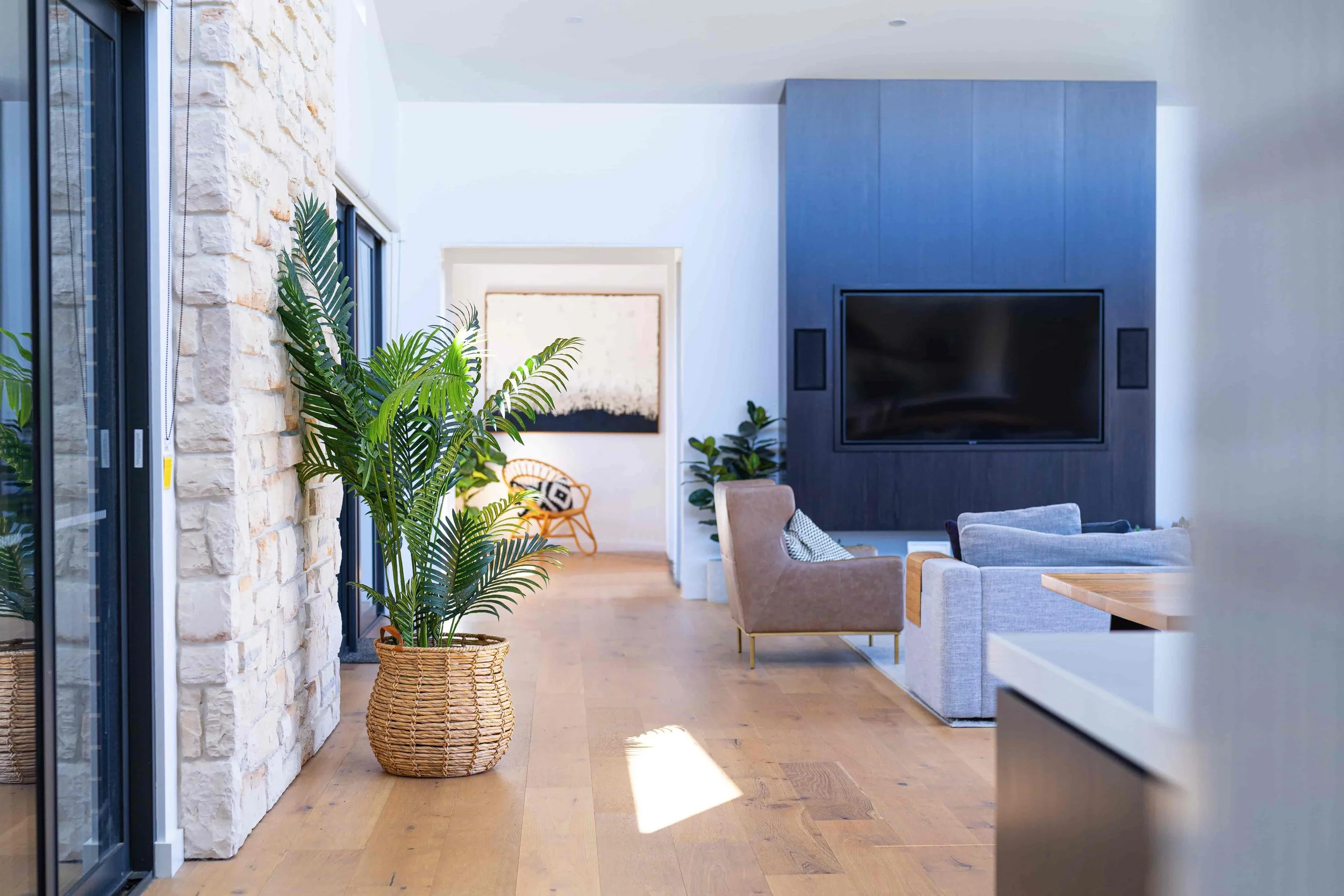 A modern open living area with a feature stone clad wall.