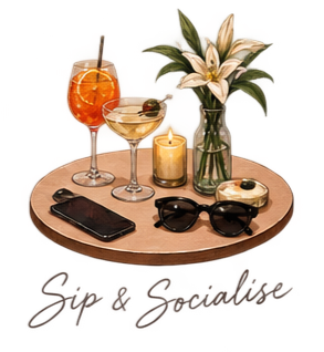 Tray with three drinks, a flower vase, a lit candle, sunglasses, and a phone. Background is red. Text says 'Sip & Smile'.