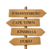 Wooden directional signpost with four arrows pointing right, labeled Johannesburg, Cape Town, Kinshasa, and Dubai.