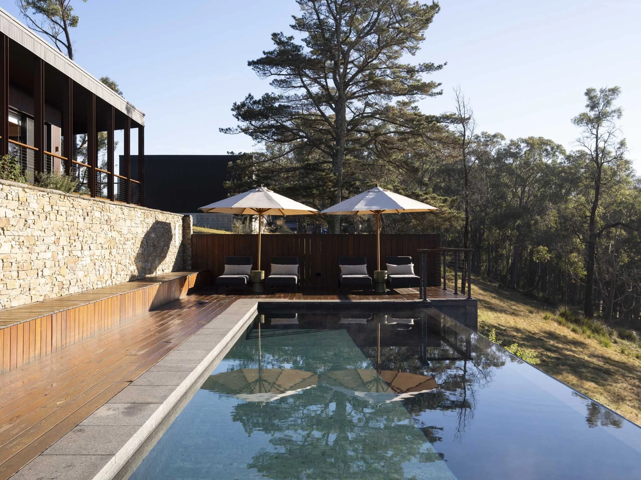The heated infinity pool is a focus of the Five Songs experience; overlooking the ridges of Blue Mountains National Park, enjoy a relaxing lounge chair or swim some laps to reinvigorate your senses. #Poolside #RusticLuxury #RelaxAndRecharge