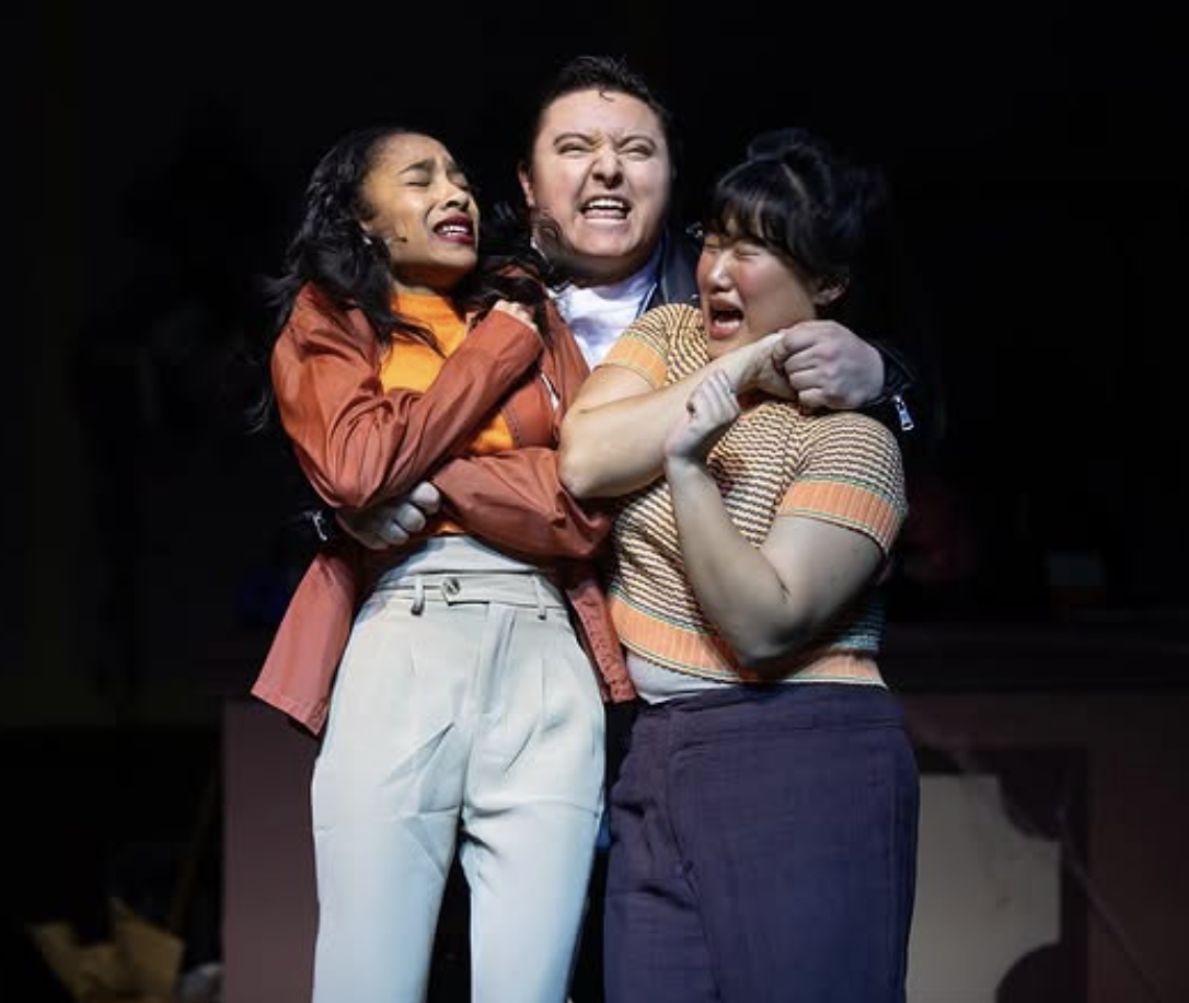 Three women in a dramatic scene showing emotional distress, with two women crying and one woman holding them back.