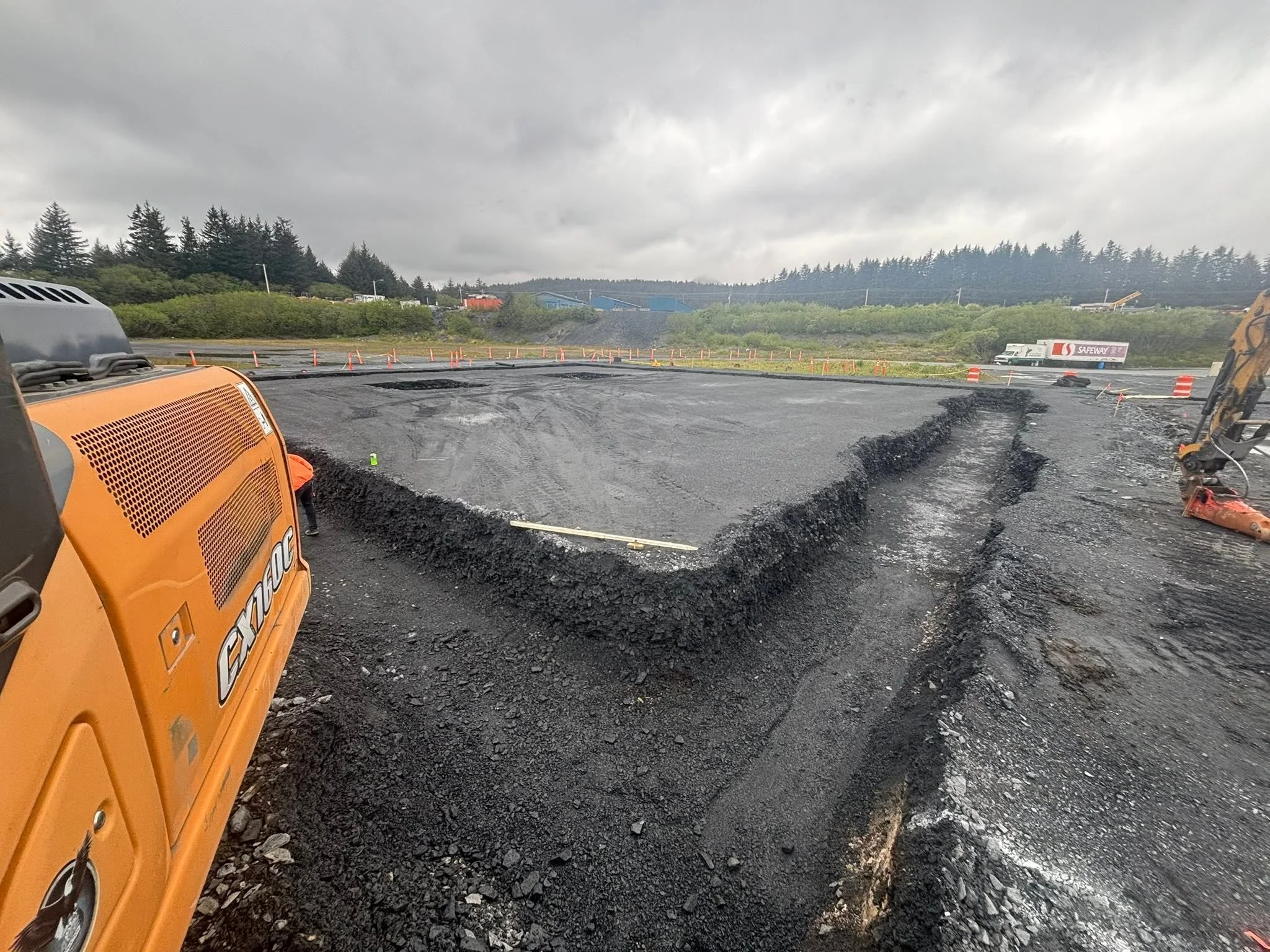 Site preparation and excavation for a building foundation with heavy construction equipment.