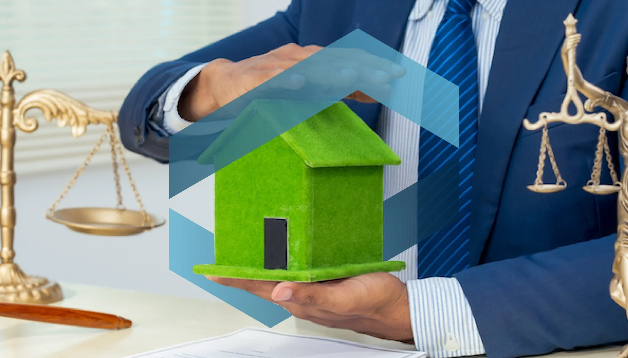 Person in a suit holding a small green model house, with scales of justice in the background.