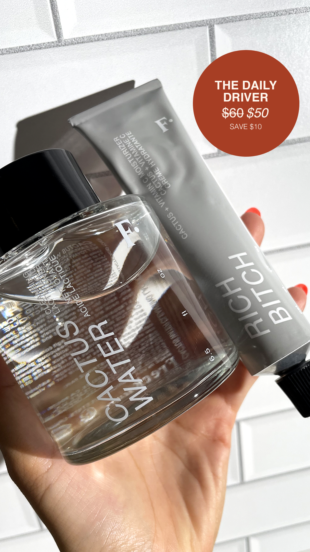 A hand holding a clear glass bottle with white text and a black cap, containing a transparent liquid, with a silver tube of skincare product and a red circular sale sticker in the background.