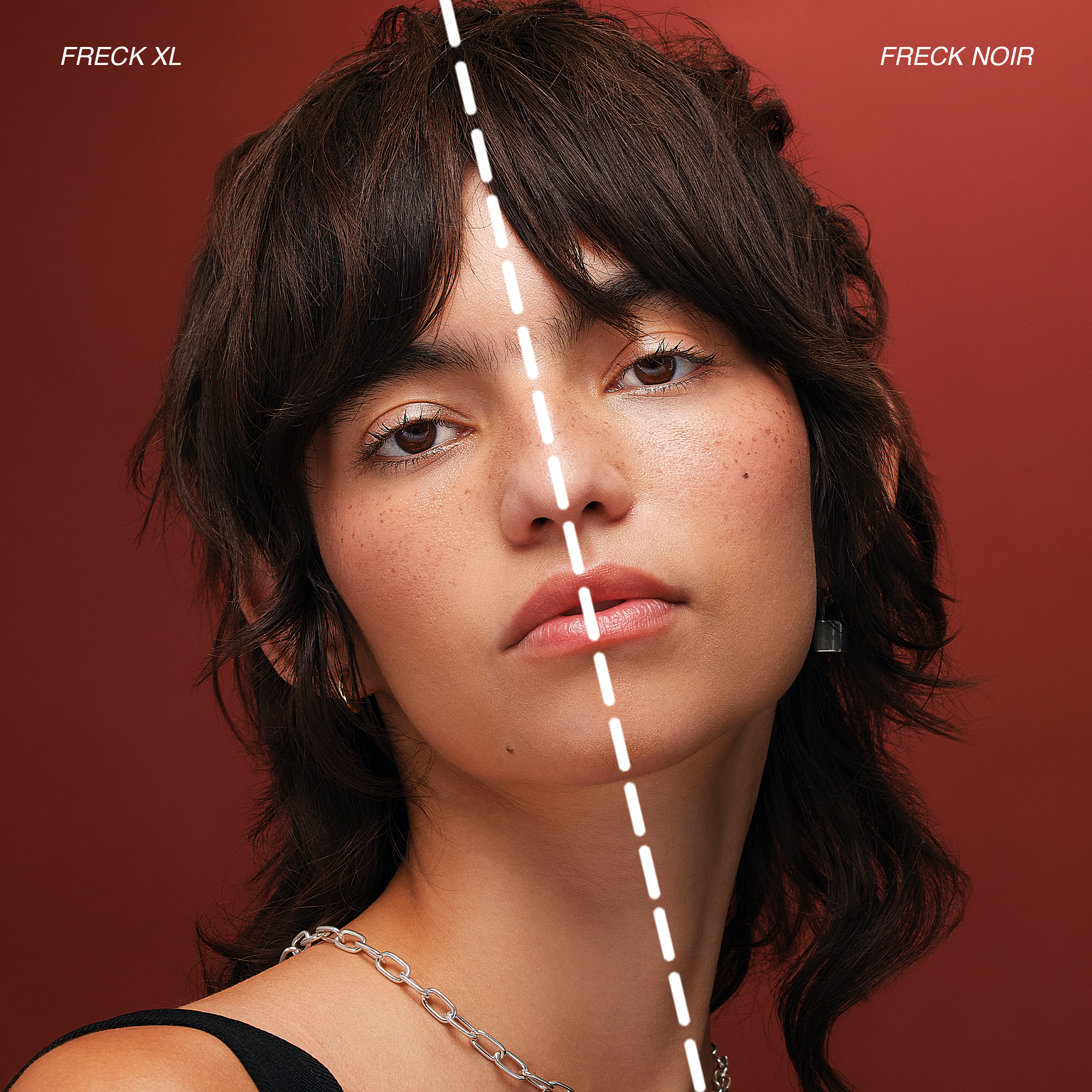 A close-up photo of a woman's face with dark brown, wavy, layered hair, wearing makeup with neutral tones, a silver chain necklace, and a black sleeveless top, against a red background. Image is split showing half Freck OG and half Freck Noir.