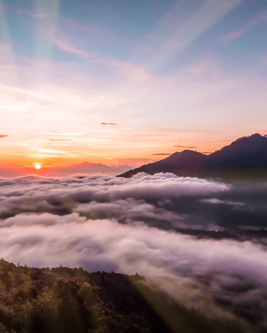 Sunset over mountains with clouds in the valley