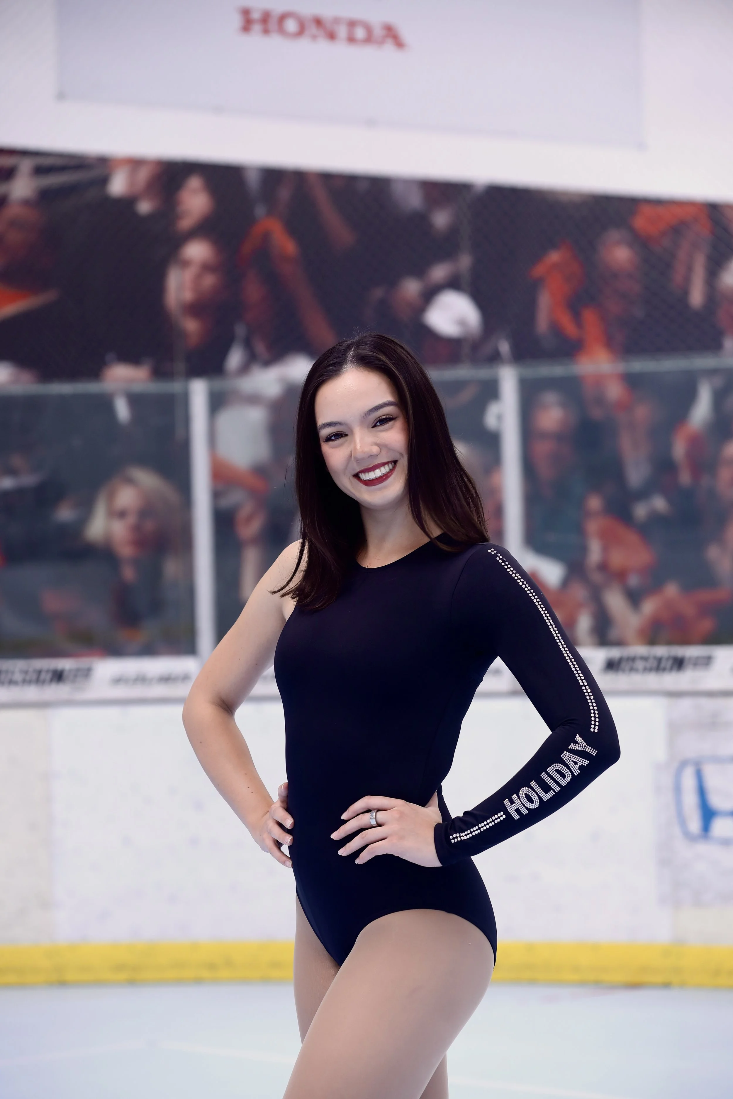 A female figure skater in a black long-sleeve costume with