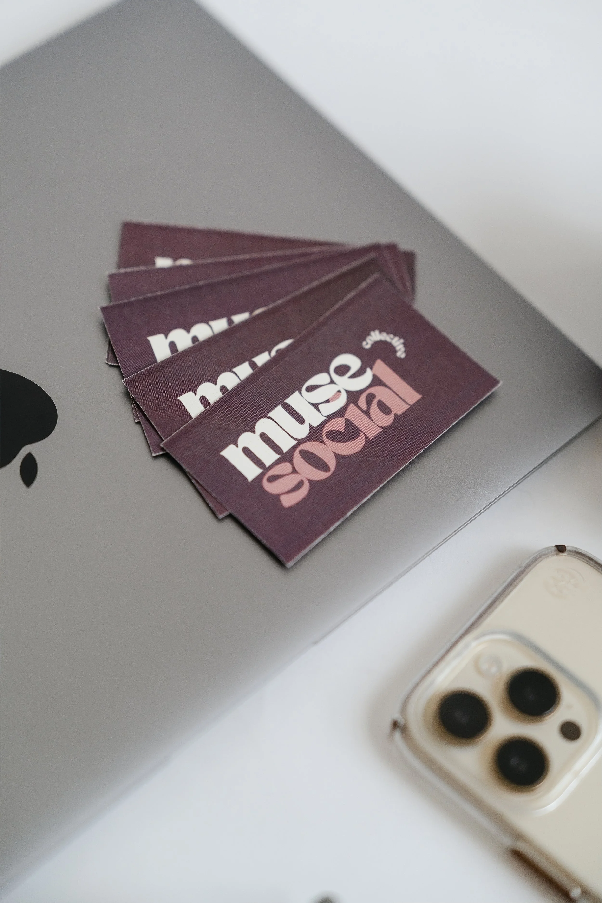 Close-up of a stack of purple business cards with the text 'music school' on them, resting on a grey surface.