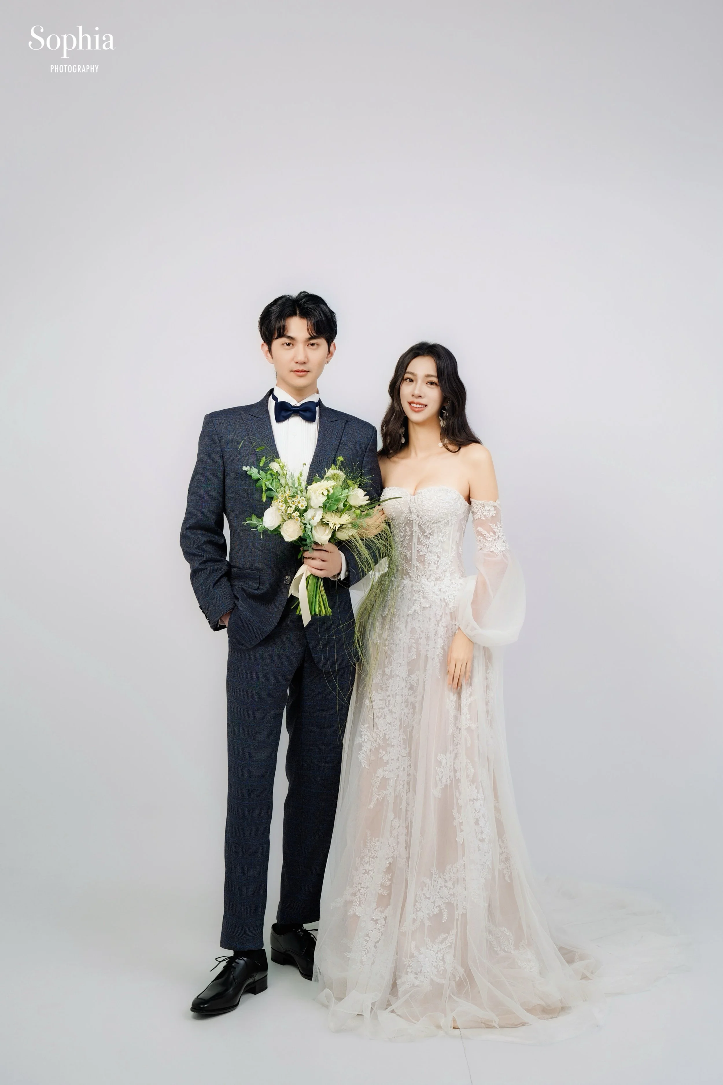 棚拍婚紗攝影，新人穿著白紗與黑色西裝的經典婚紗合照