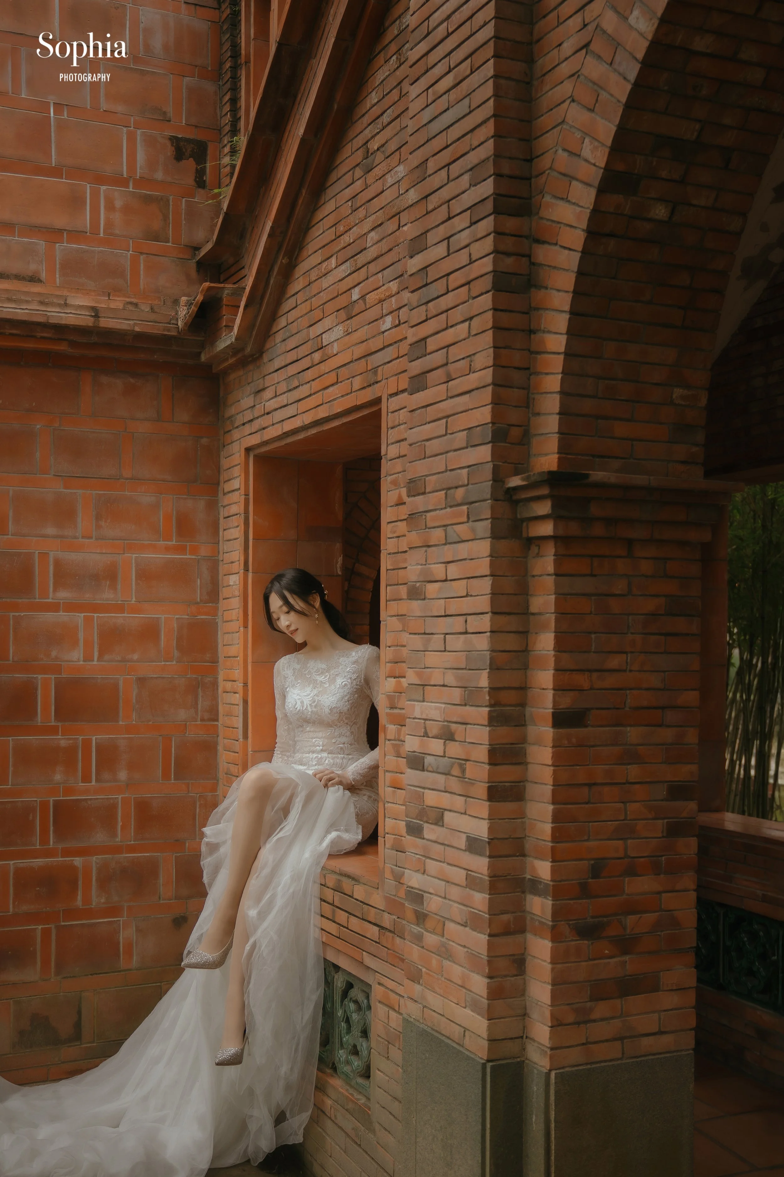 紅磚建築外景婚紗攝影，新娘穿著白紗在建築光影中拍攝個人婚紗照