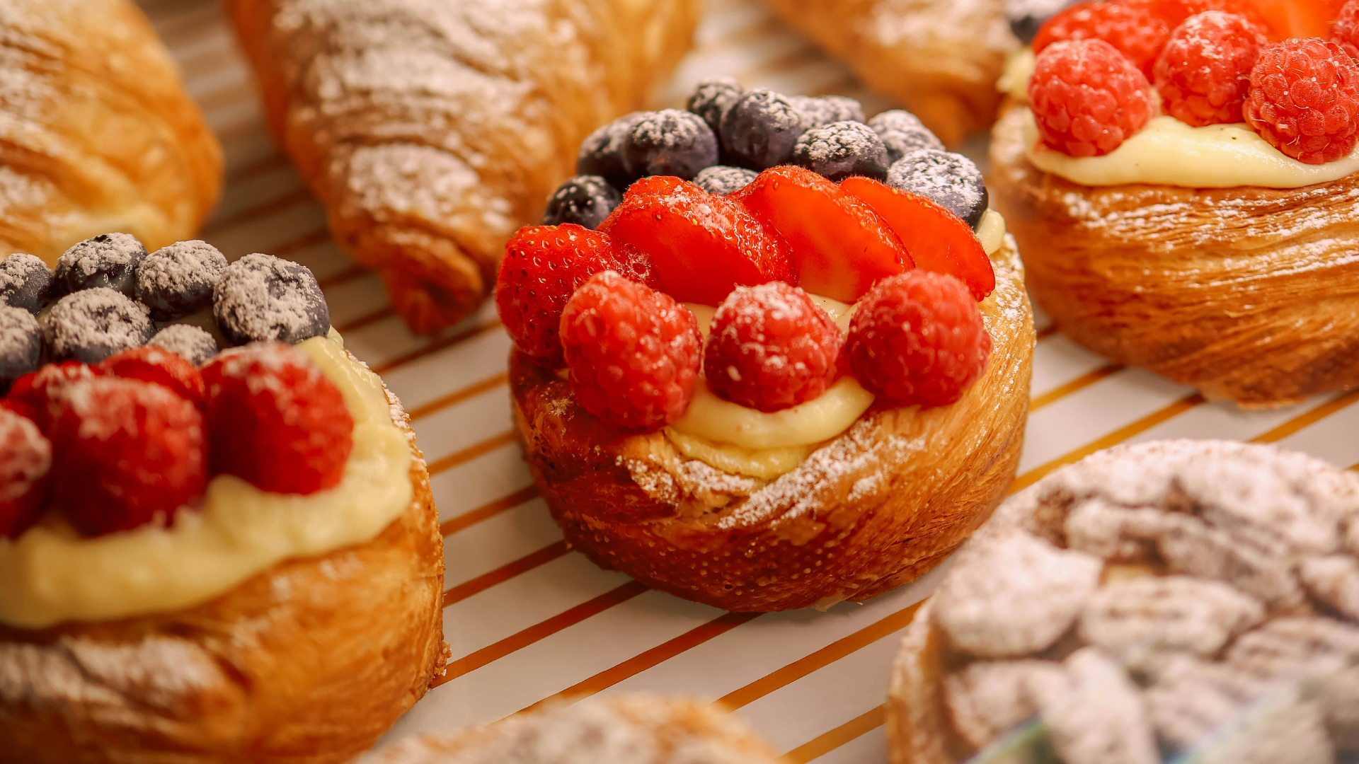 Fresh pastries and fruit tarts representing baking tools and bakeware.