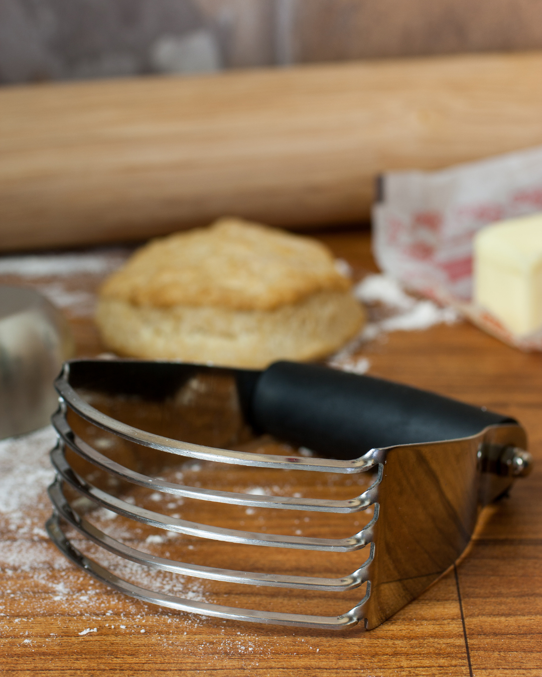 Stainless steel pastry blender with curved blades and a black handle for cutting butter into flour.