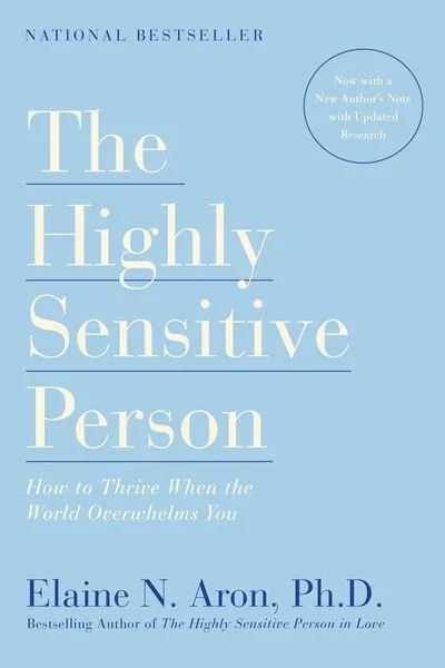 Buchcover von 'The Highly Sensitive Person' von Elaine N. Aron, mit blauem Hintergrund, weißen und blauen Text, Titel in großen Schriftarten, Untertitel und Autorennamen.