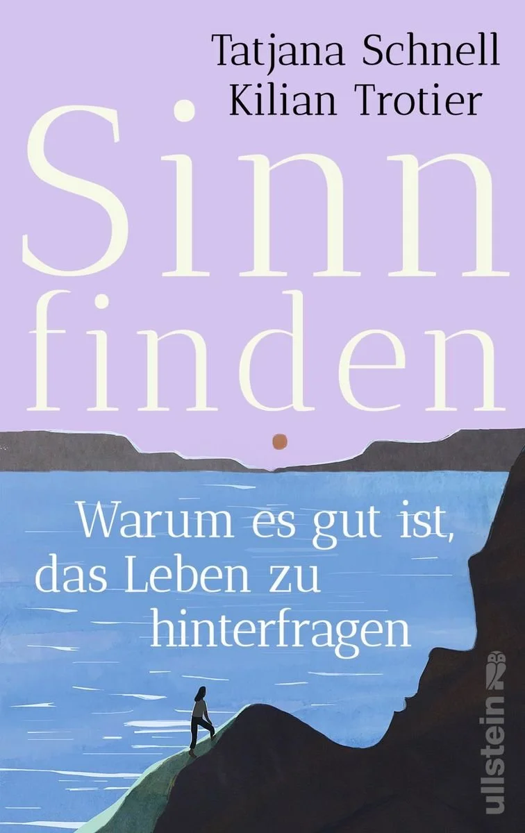 Buchcover mit Titel 'Sinn finden' von Tatjana Schnell und Kilian Trotier, ermutigt dazu, das Leben zu hinterfragen, mit einer Illustration eines Menschen, der auf einem Hügel am Wasser steht, bei Sonnenaufgang oder Sonnenuntergang.