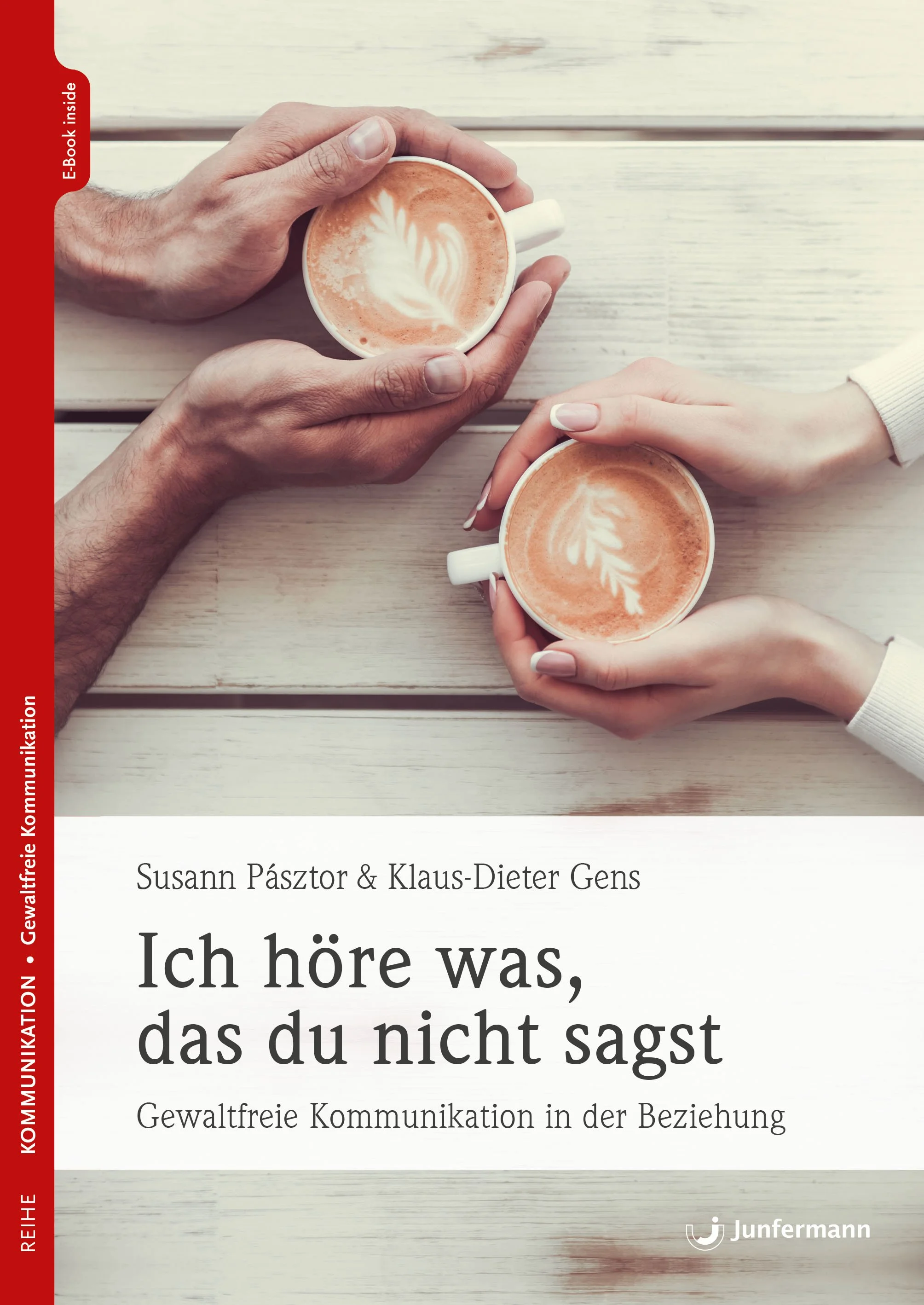 Zwei Hände halten jeweils eine Tasse mit Kaffee, auf dem Kaffee ist ein Milchschaumherz. Der Hintergrund ist eine helle, weiße Holzoberfläche.