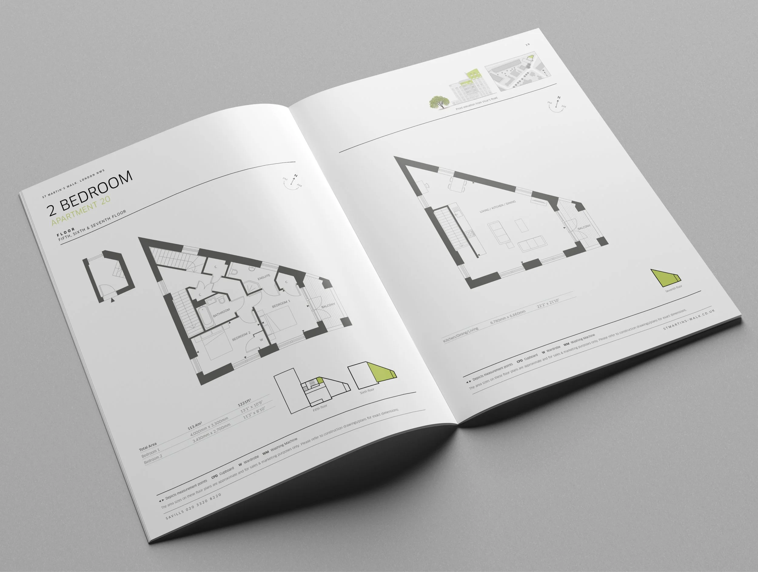 Open architectural blueprint booklet showing two-bedroom apartment floor plans with detailed room layouts and measurements, placed on a gray surface.
