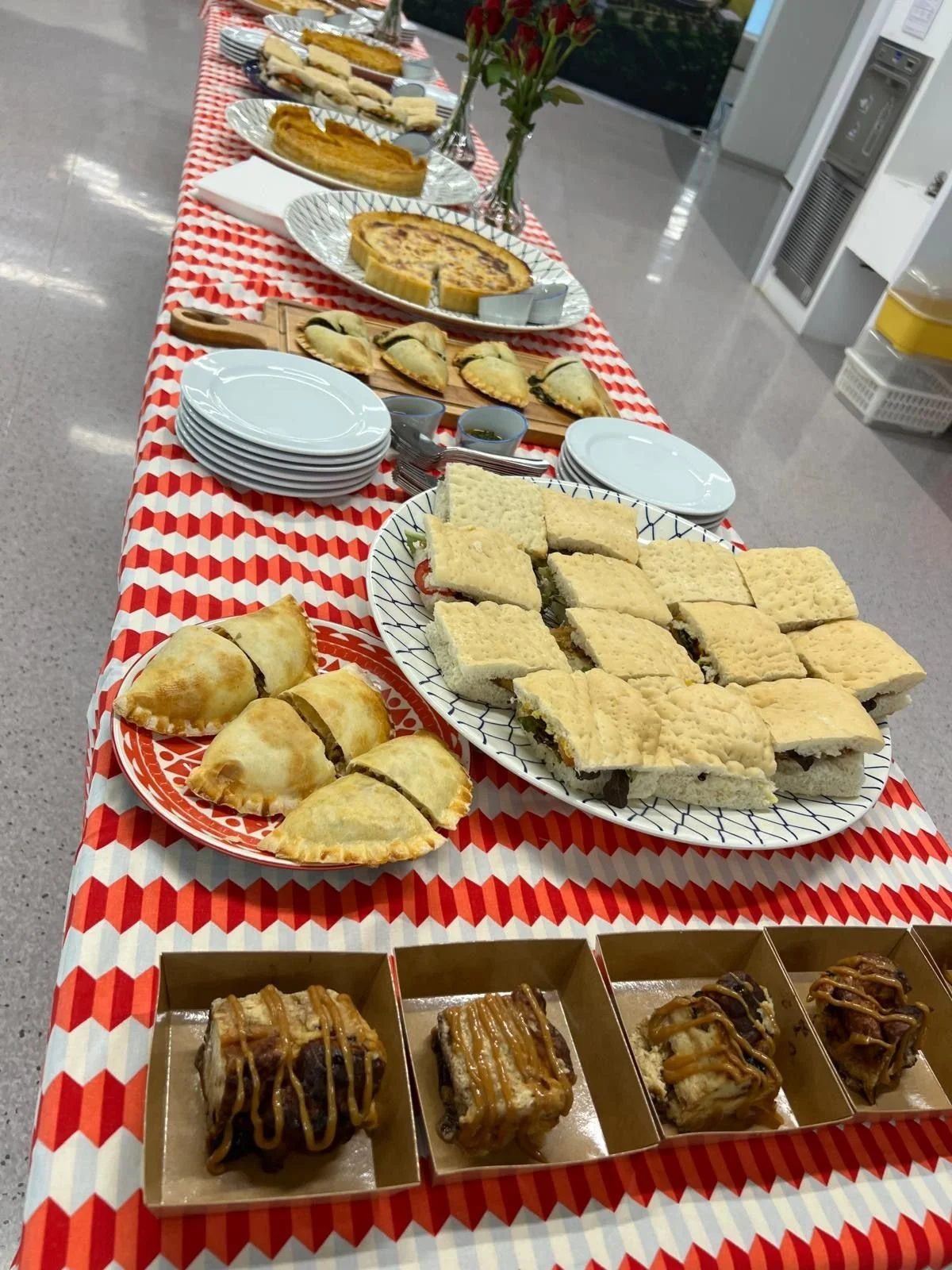Focaccia sandwiches and empanadas on a catering table