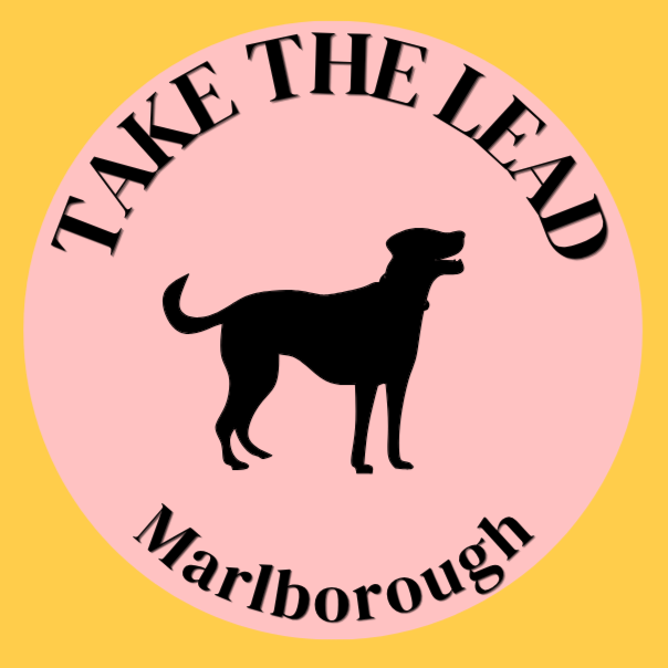 A logo with a pink circle background and black text that says "Take the Lead" at the top and "Marlborough" at the bottom. Contains a silhouette of a dog in the center.