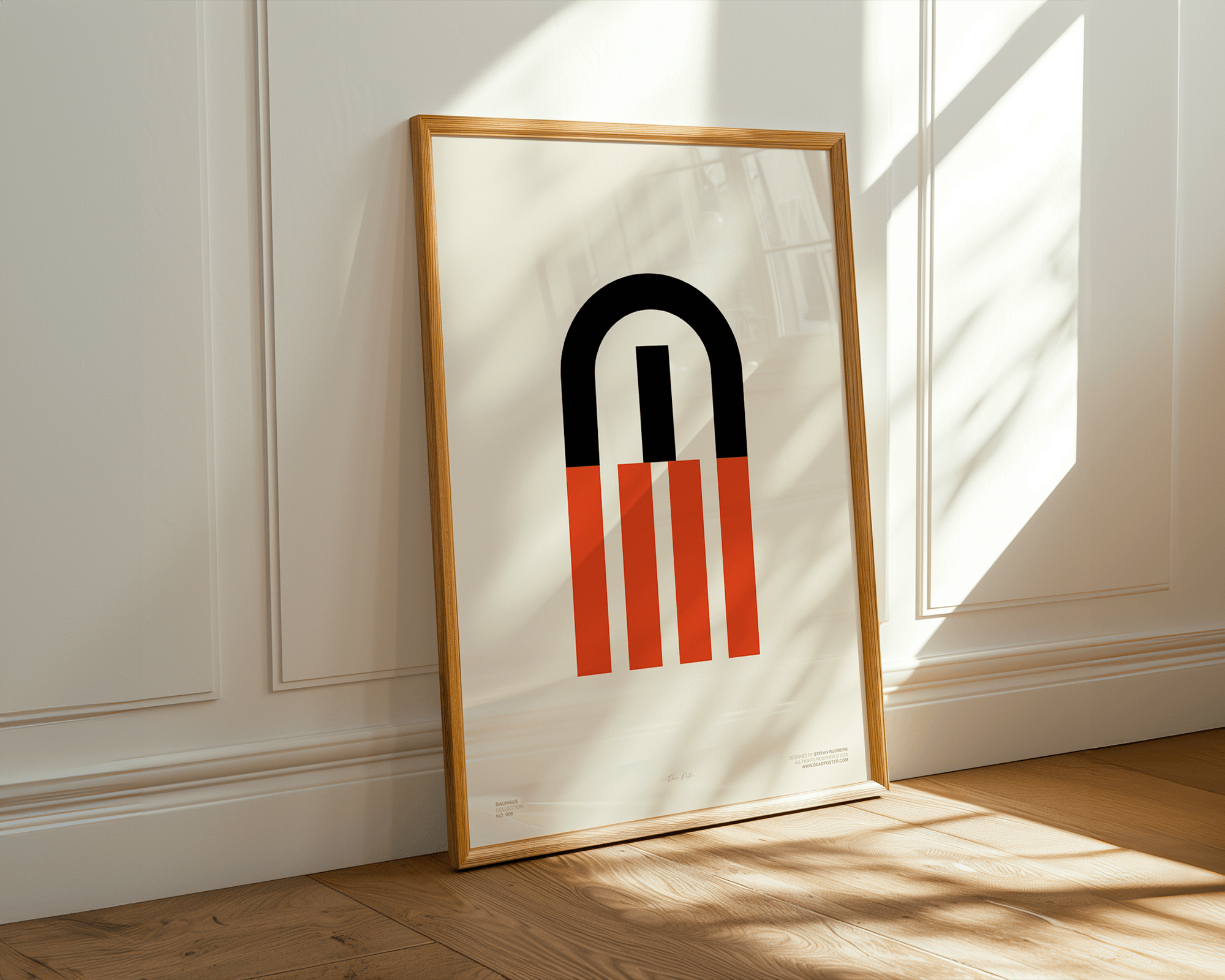 En indrammet plakat med et grafisk design, der viser en sort, rød og orange magnet med længdegrafer, der er placeret på en træbund, og står mod en hvid væg med paneler.