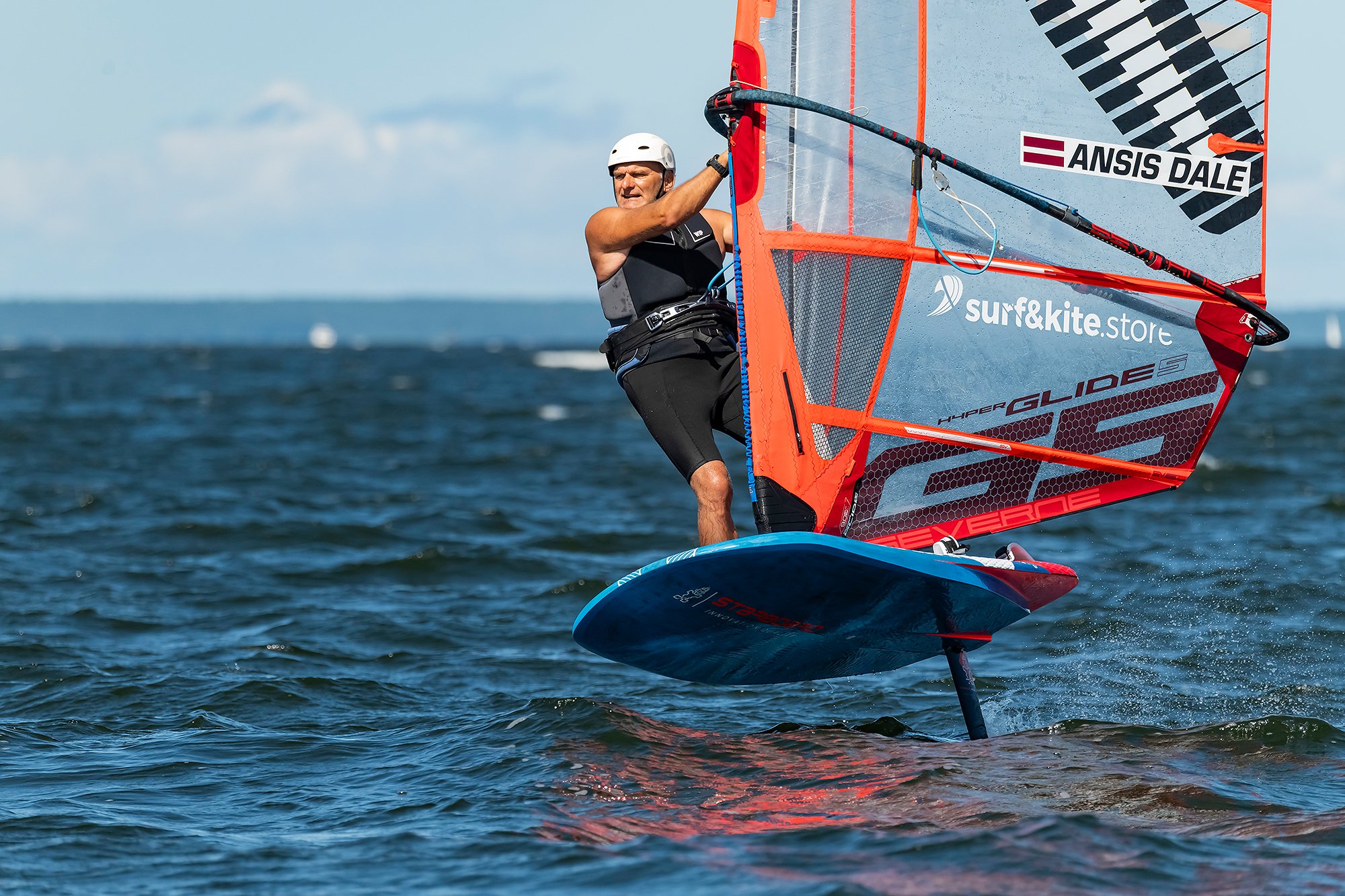 Man windsurfing on a body of water on a clear day.