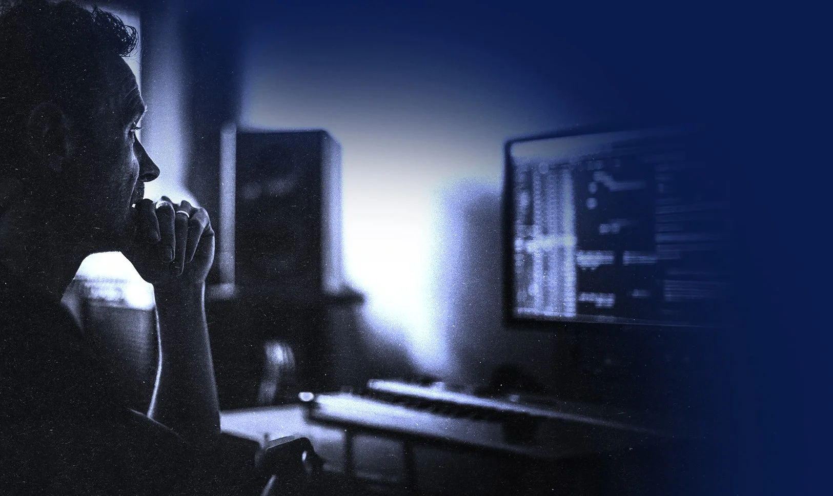 Ian from EMM East Midlands Mastering sitting at a desk in front of a computer monitor, focusing on mastering