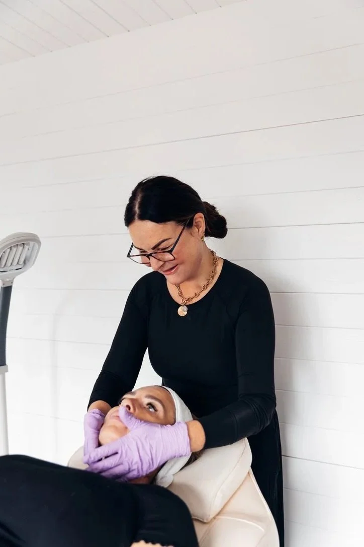 Photo of a female skincare professional performing a facial peel on a female patient to improve skin texture and pigmentation at a modern skin clinic in poole