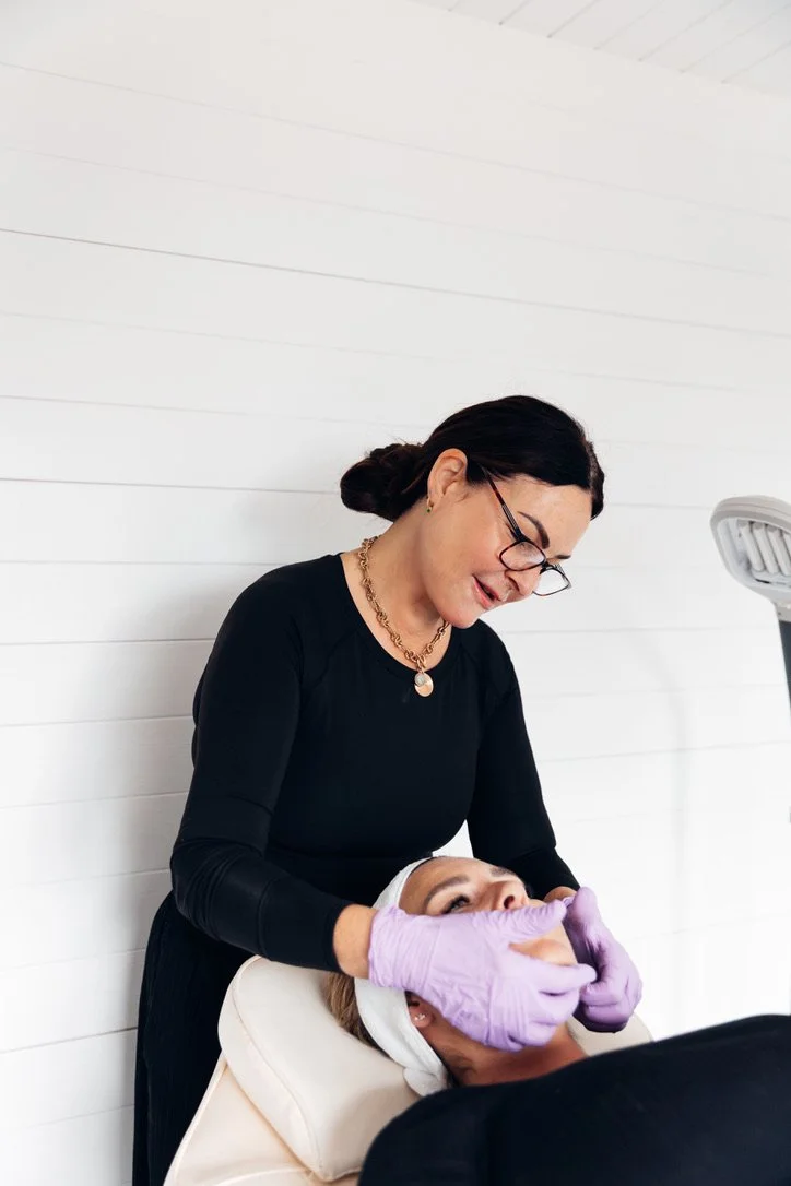A beauty professional performing a facial treatment on a client in a clinic setting in Poole, Dorset.