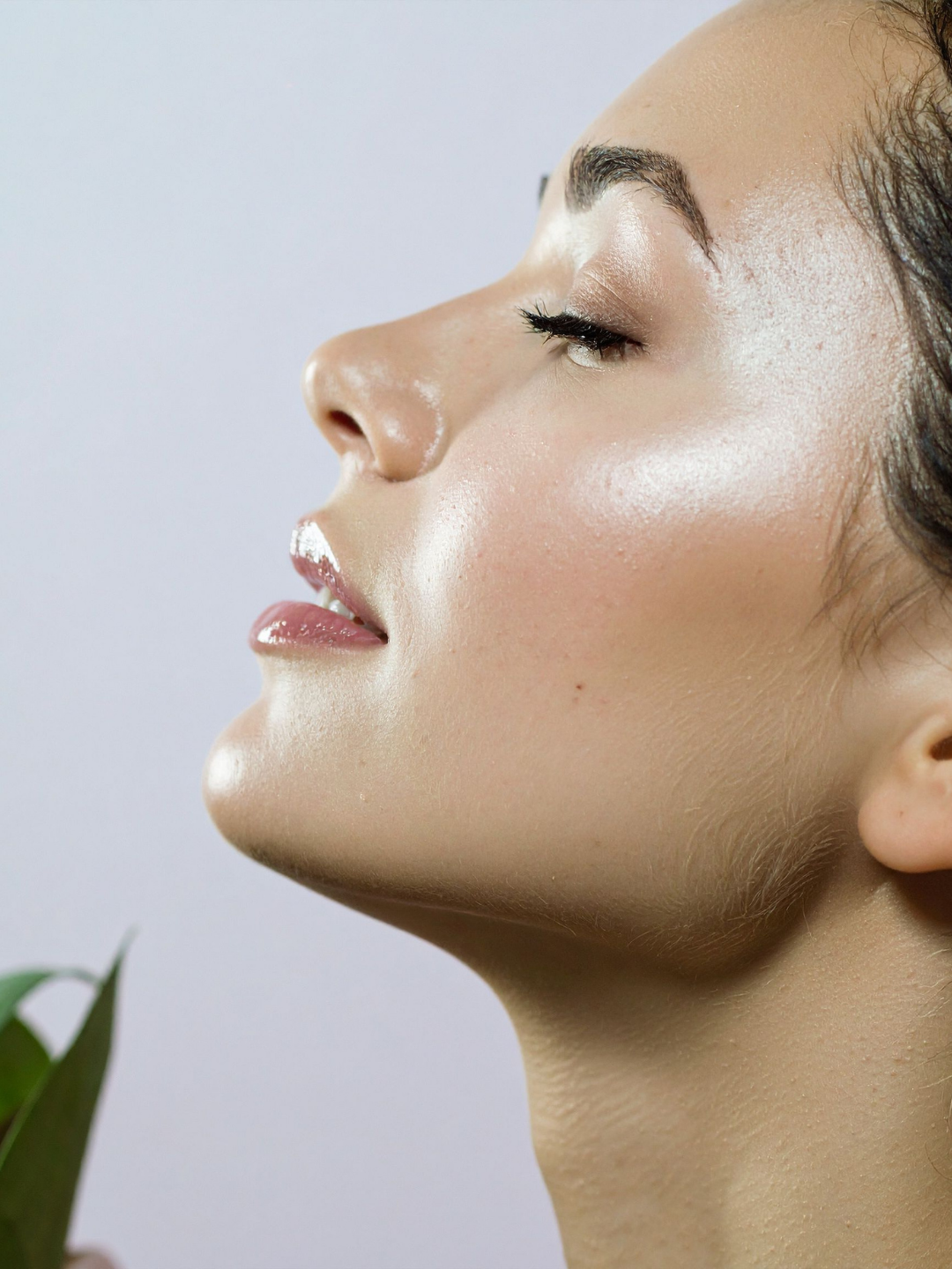 Side image of a woman with beautiful dewy skin lifting her head up high following Profhilo filler treatment to achieve dewy skin