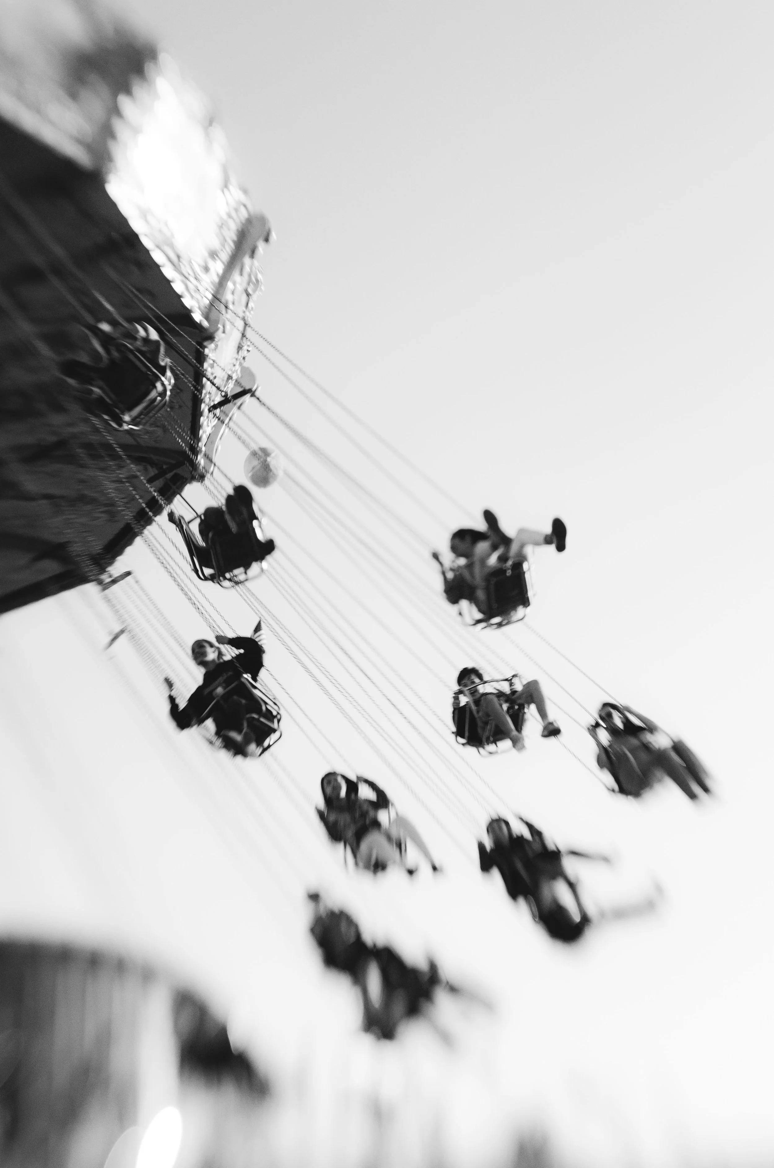 Children riding on a swing ride at an amusement park during the daytime.