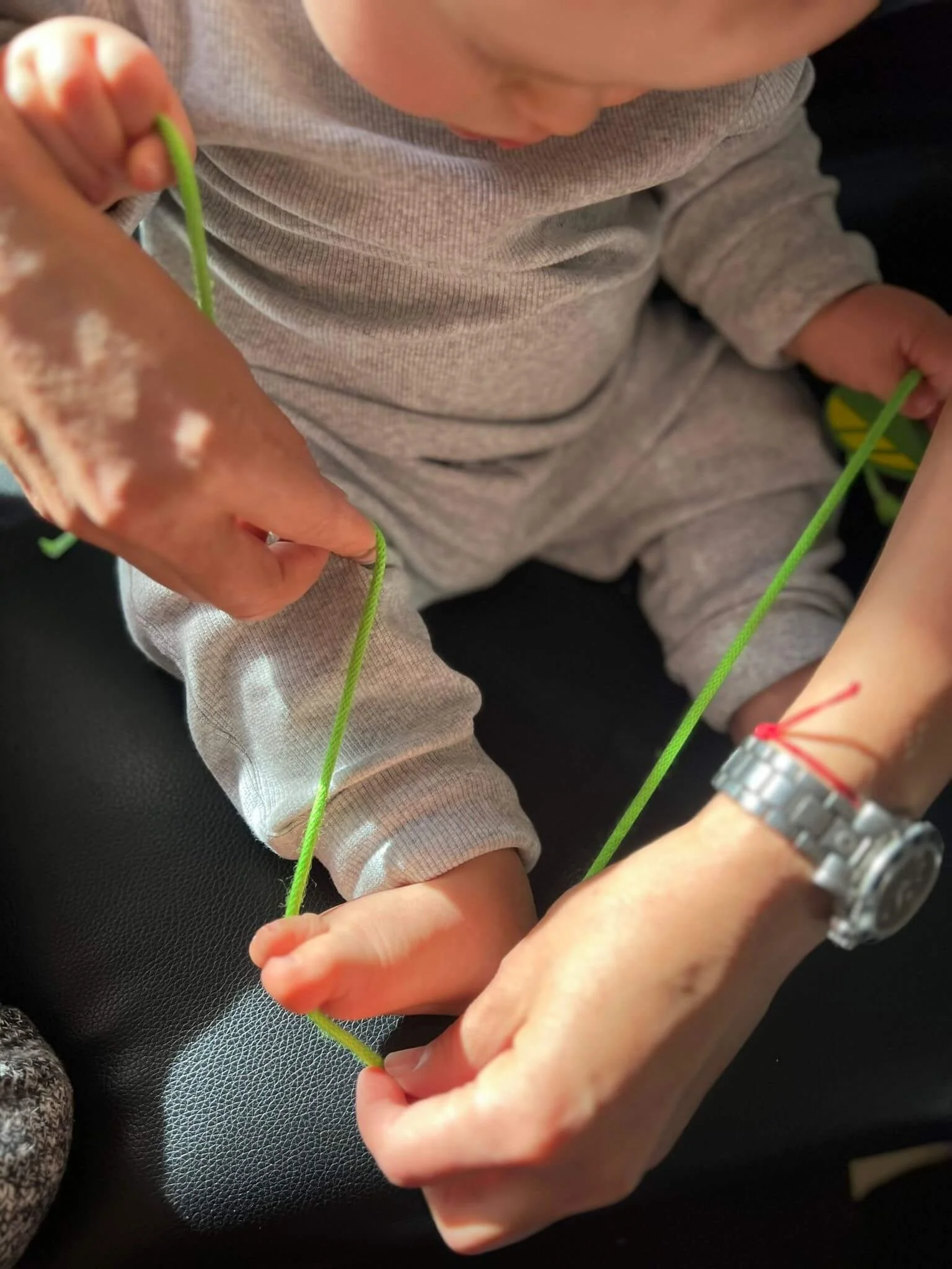 Vanessa Keel engaging in playful sensory integration with a baby in Zurich. Using a string, she gently promotes coordination, body awareness, and nervous system development.