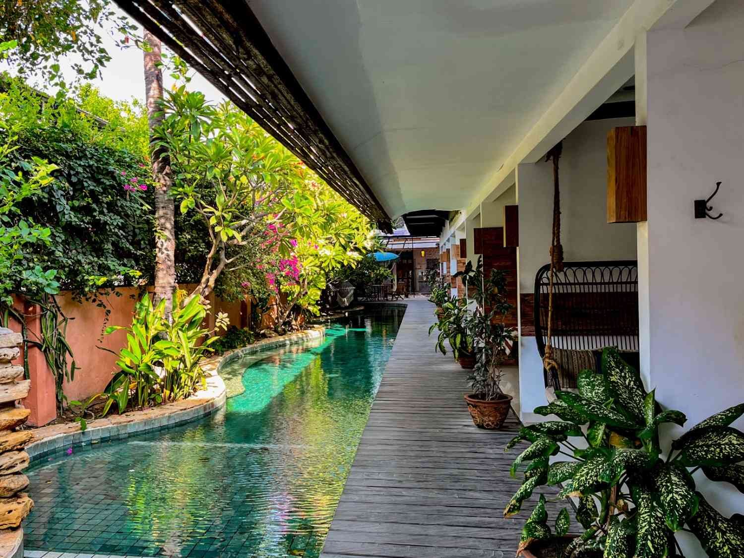 Guest-only swimming pool surrounded by tropical gardens at Pesona Beach Resort & Spa.