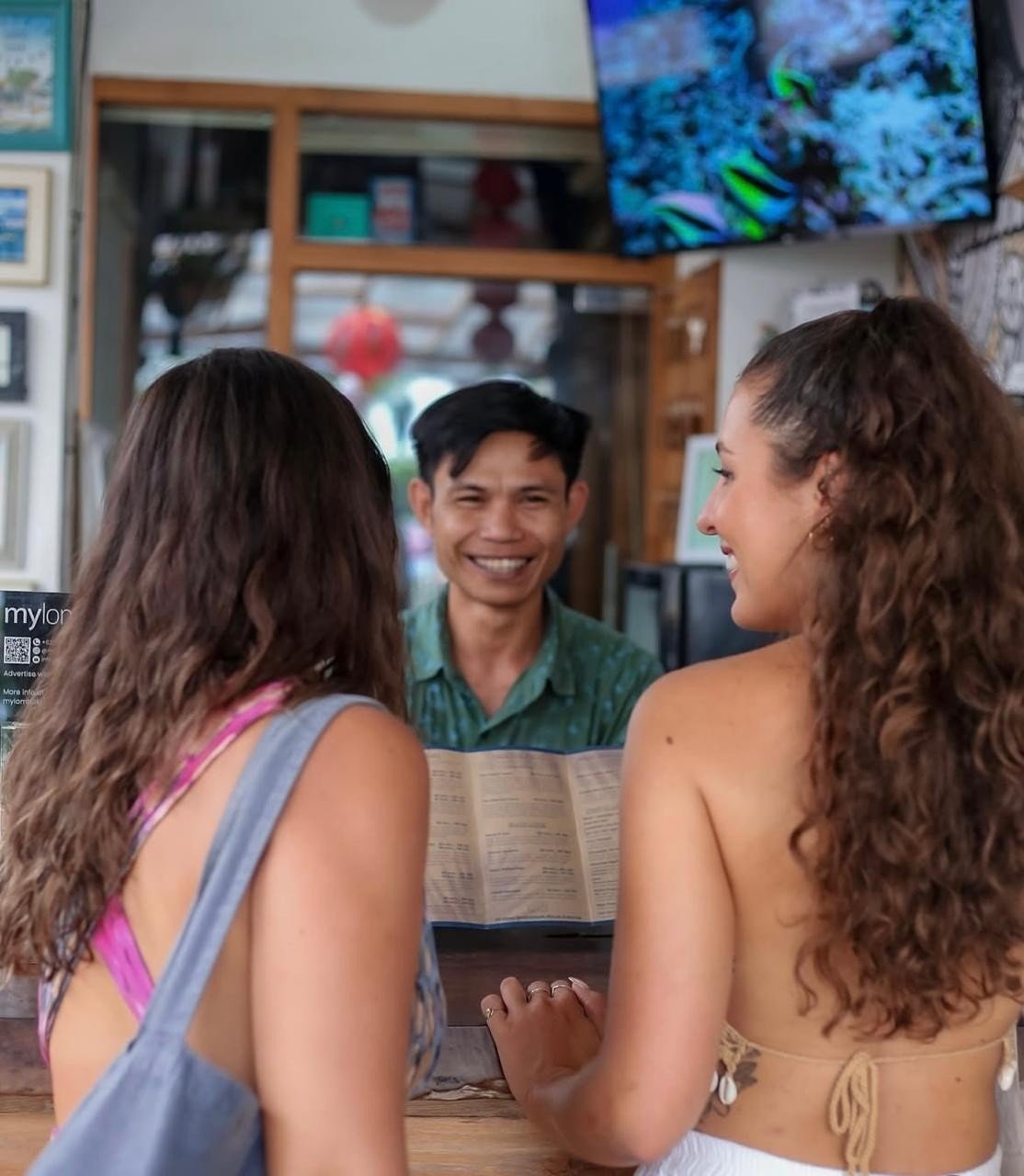 Guests checking in at the reception desk of Pesona Beach Resort & Spa in Gili Trawangan,  with assistance from the resort staff.