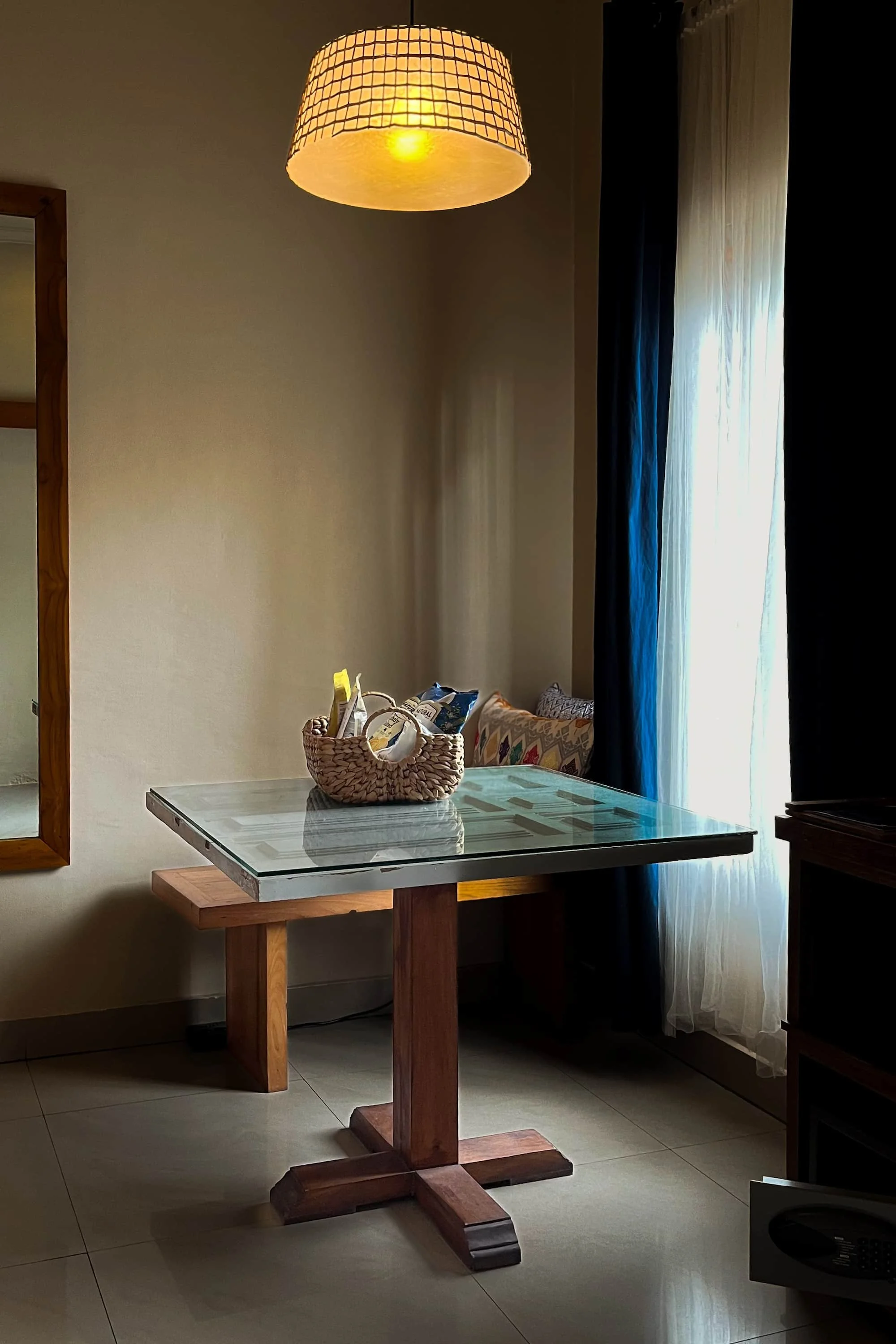 Table and welcome amenities beside a window inside a resort guest room