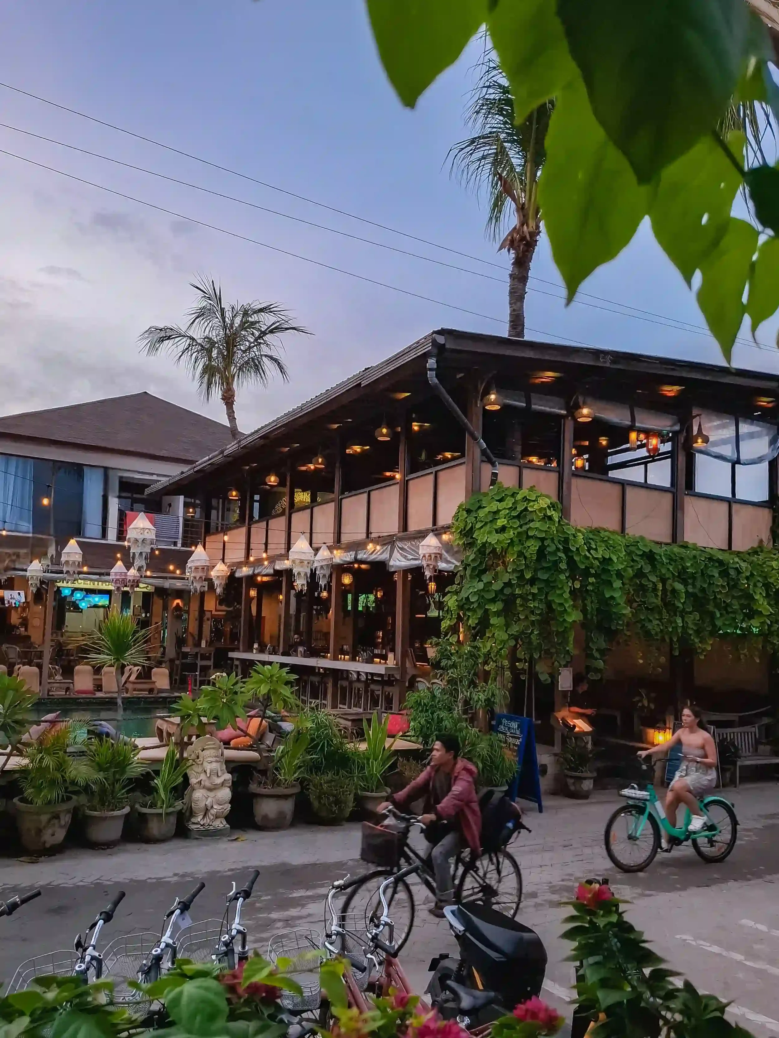 Street view of Pesona Resort Gili Trawangan with cyclists and tropical surroundings