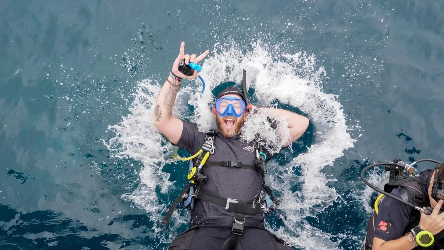Happy scuba diver surfacing after a dive in Gili Trawangan with diving gear and crystal-clear blue ocean
