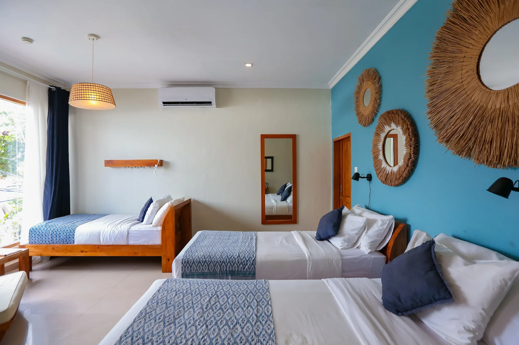 First-floor triple room with three single beds and blue wall decorations at Pesona Beach Resort